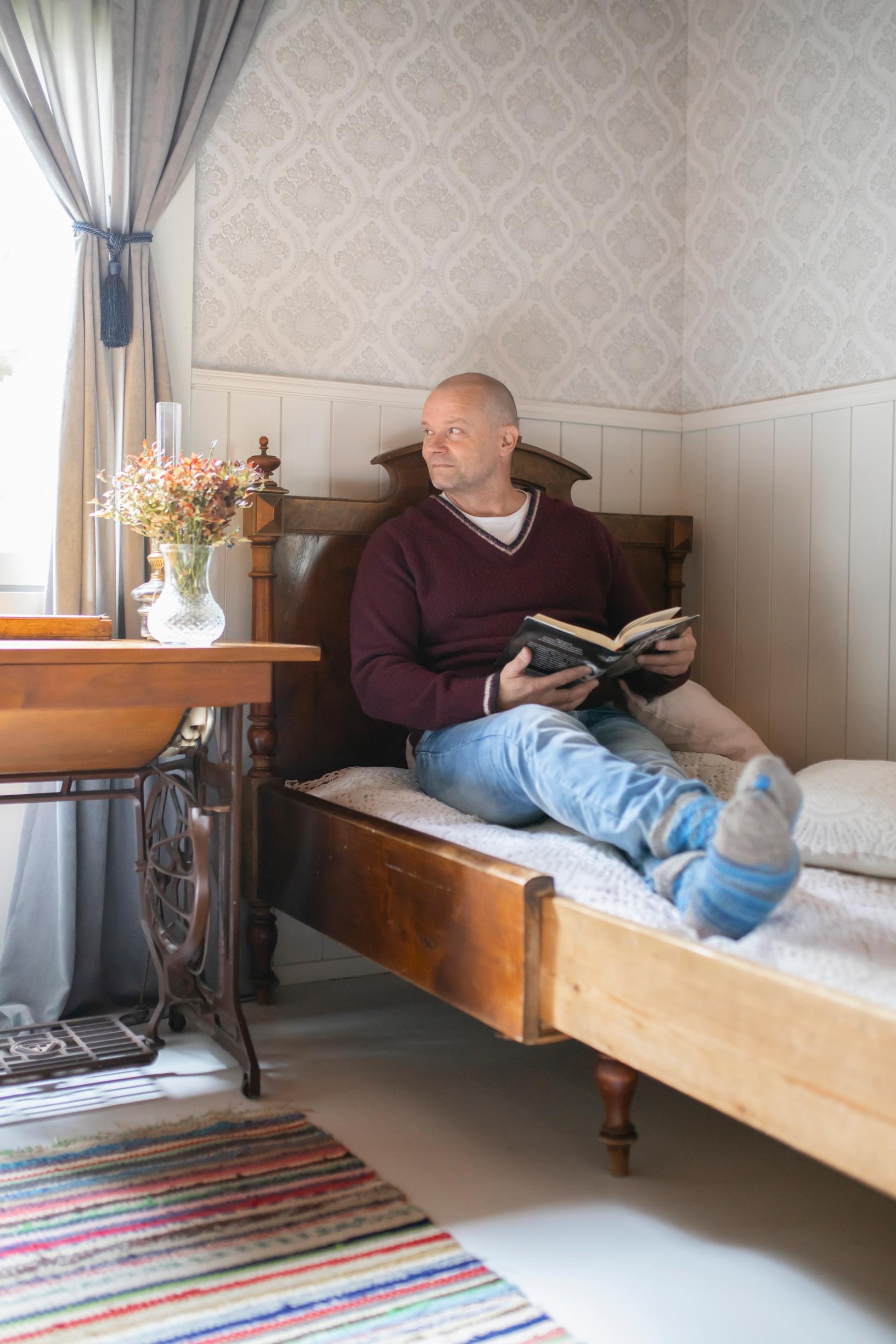 Janne lukee vanhalla sängyllä