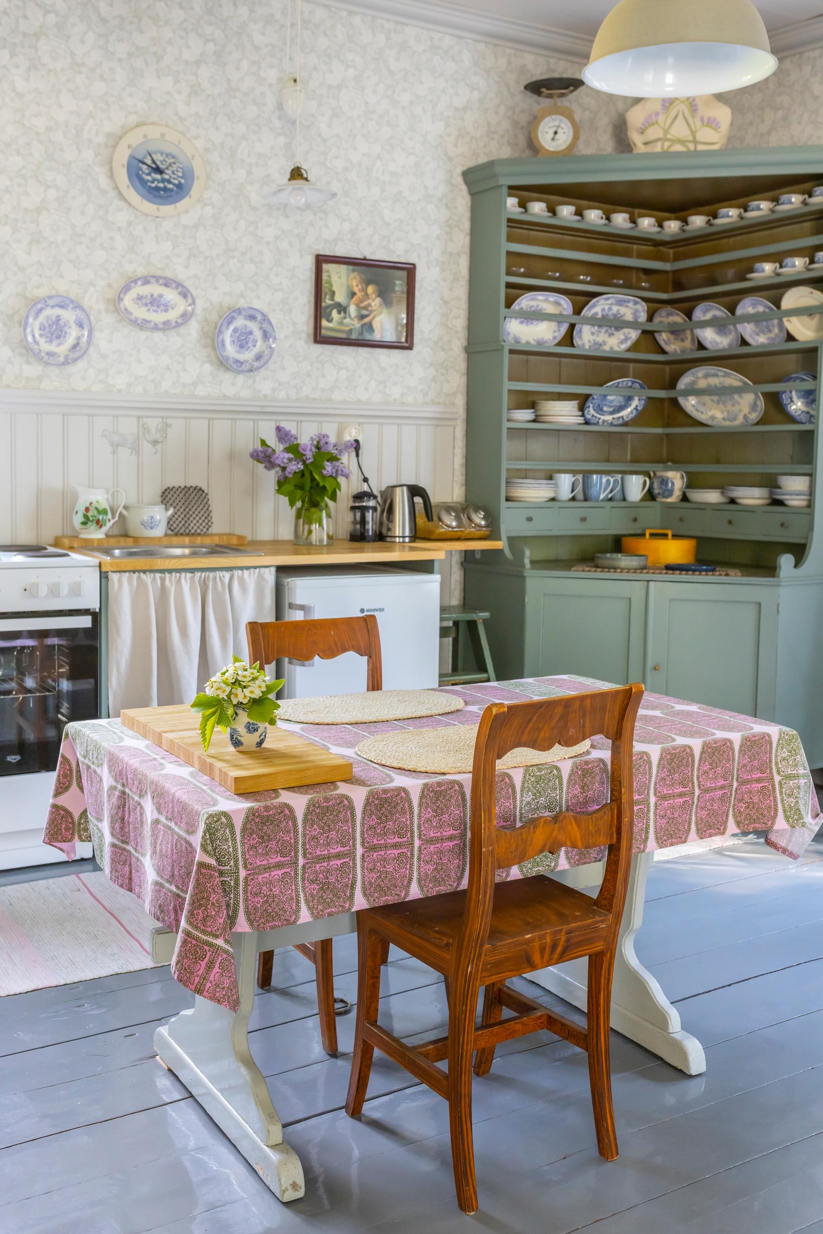 vihreäksi maalattu vanha kulmakaappi ja ruokapöytä