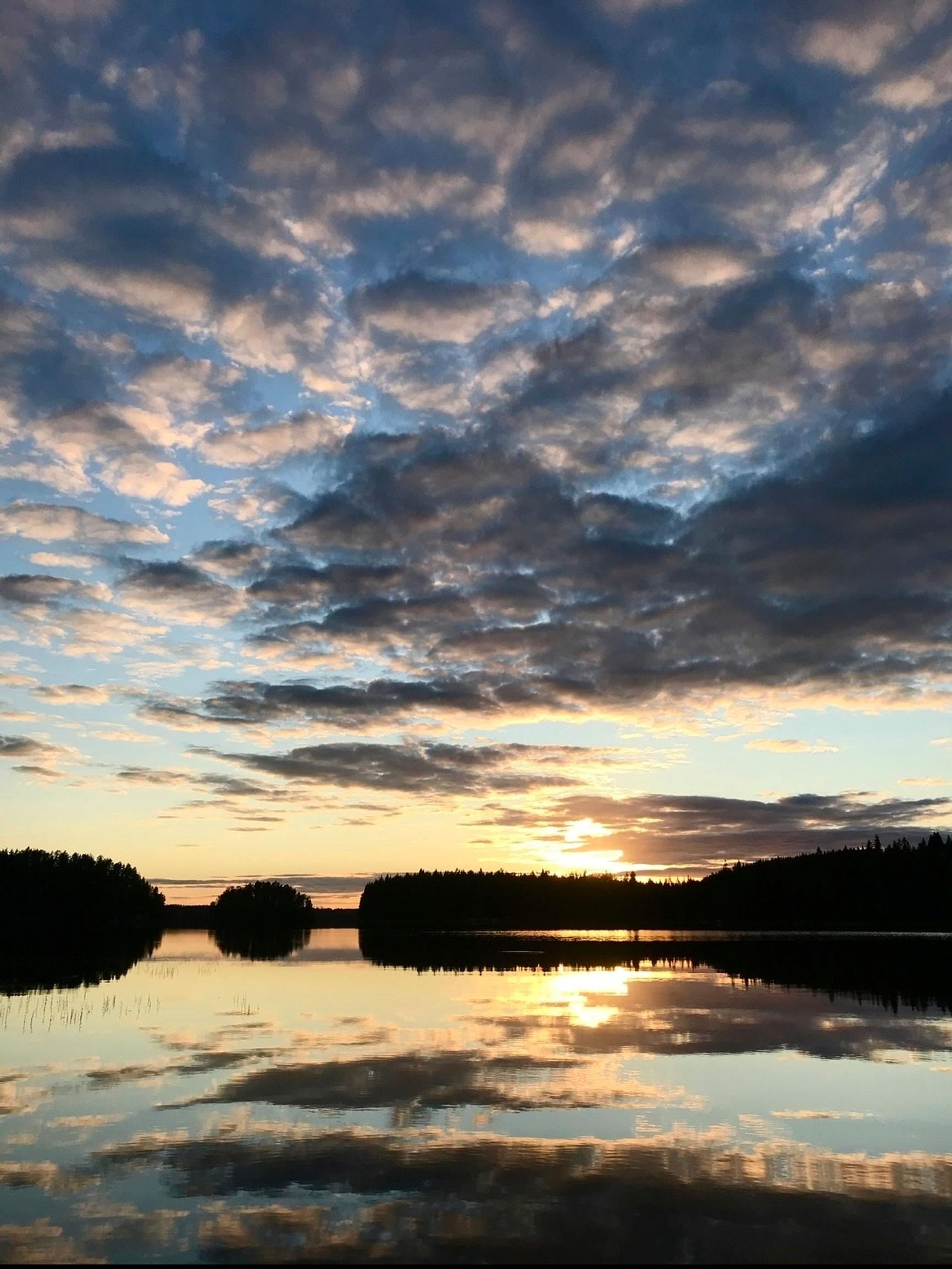 Näyttelijä Krisse Salmisen kesämökkipaikan näkymä järvelle ilta-auringossa, saaria