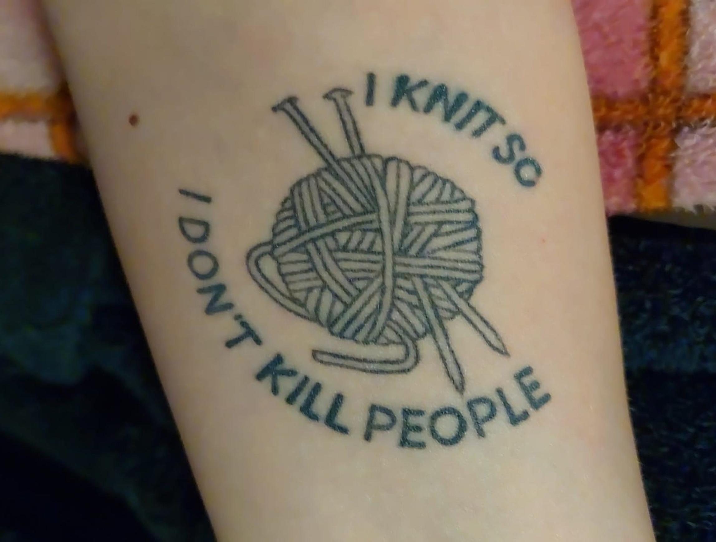 Nina Karjalaisen tatuointi, jossa lankakerä ja puikot sekä teksti ”I knit so I don't kill people”