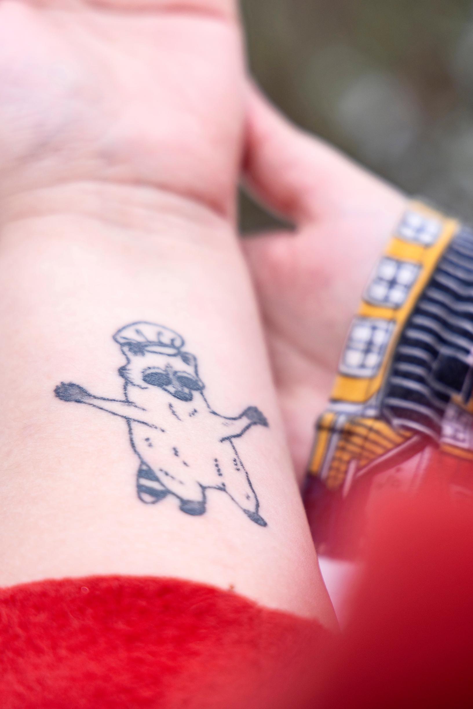 naisen vasemman ranteen alapuolella näkyy tatuointi