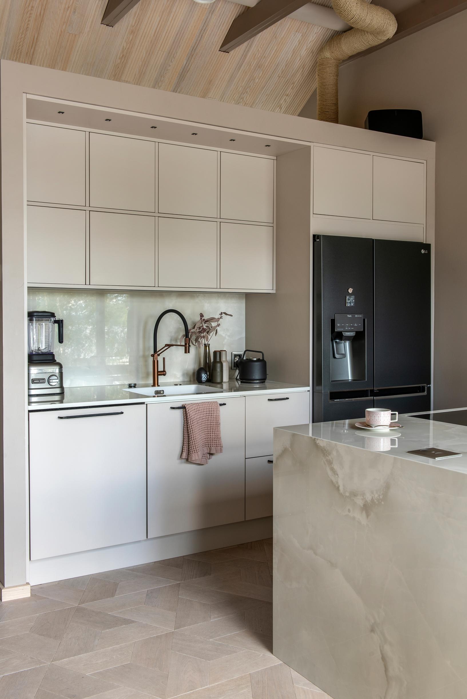 Hirsitalon kitinvärinen moderni keittiö, jossa Dekton-tasot