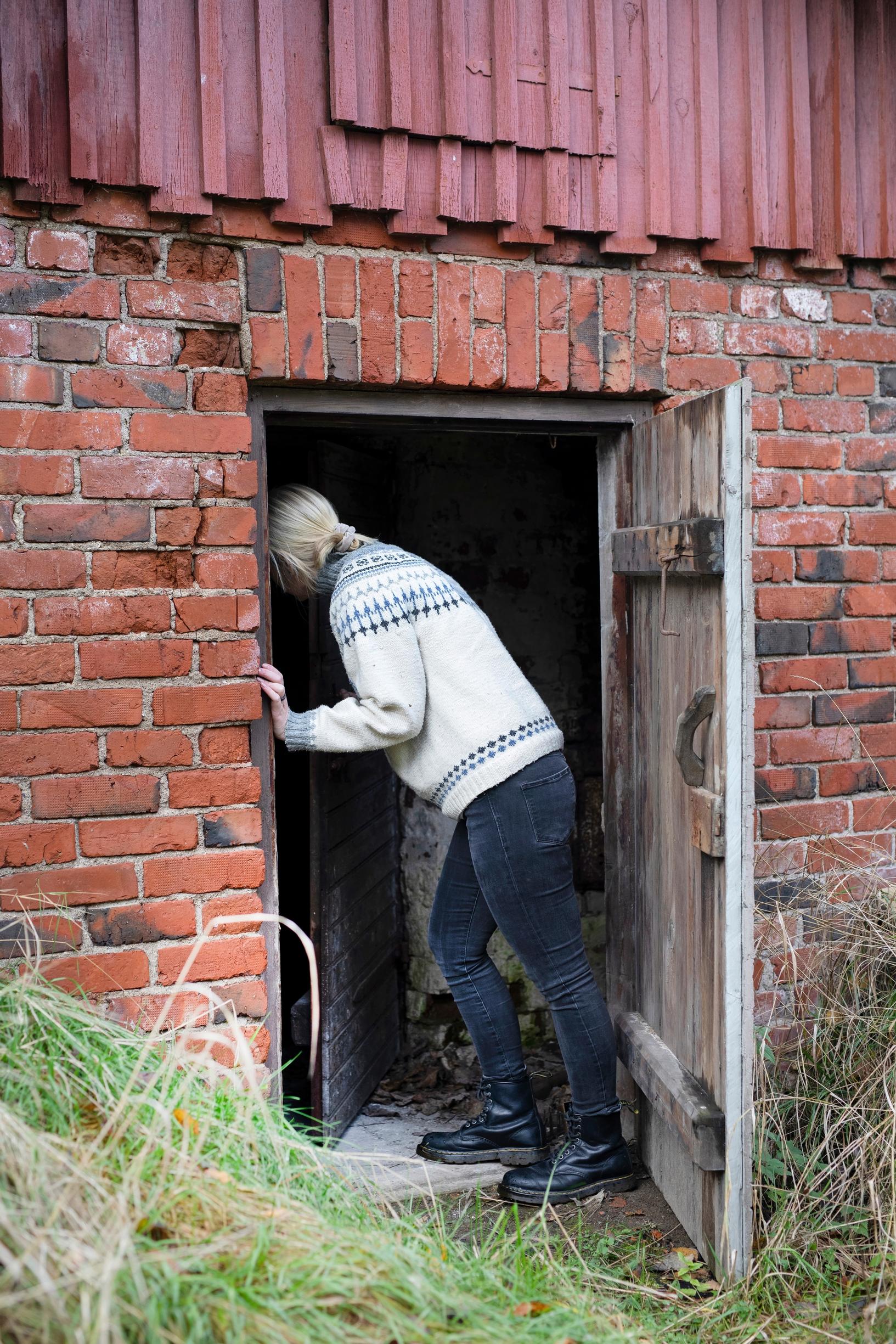 nainen hakee polttopuita liiteristä