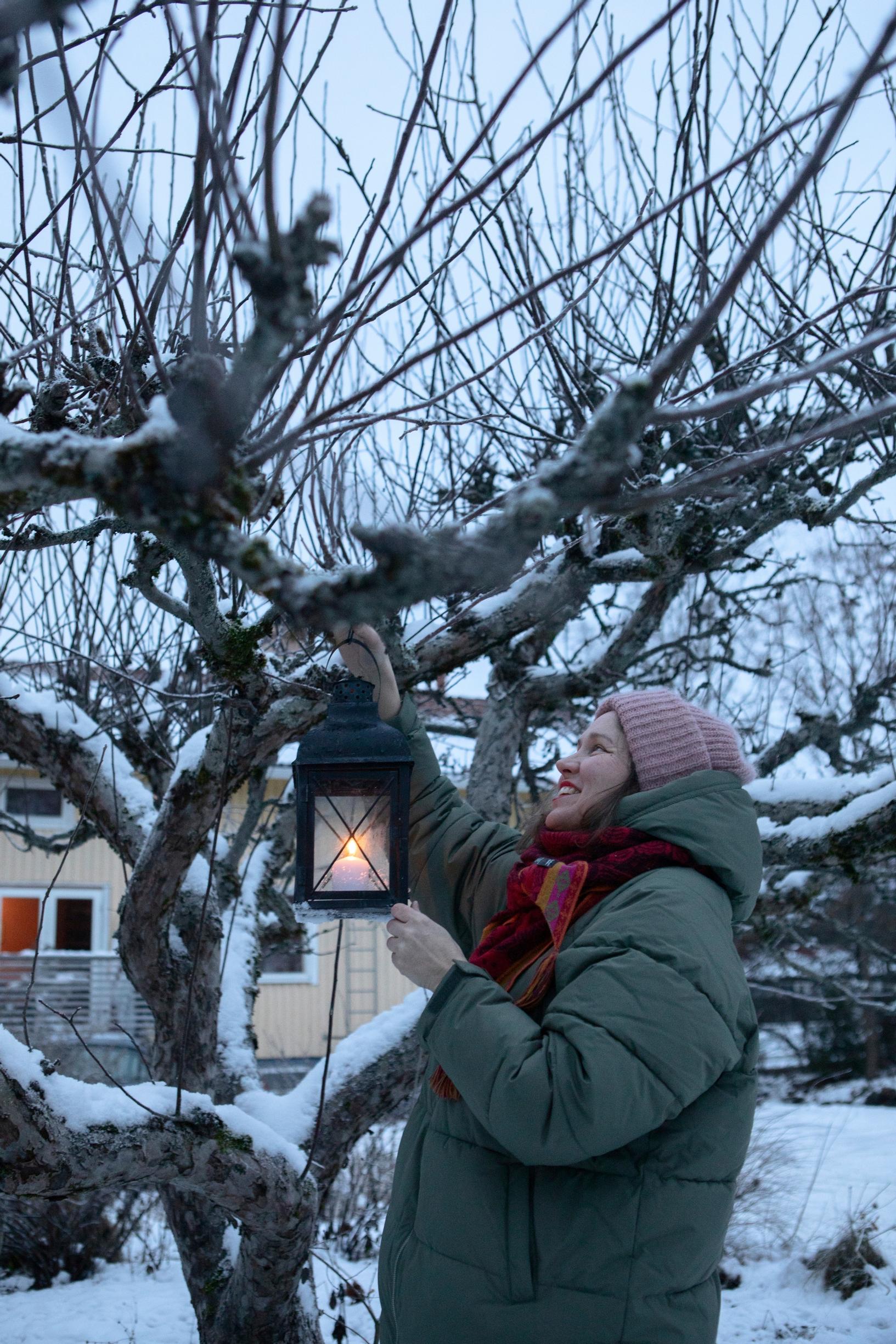 Suveka Kymäläinen ripustaa lyhtyä