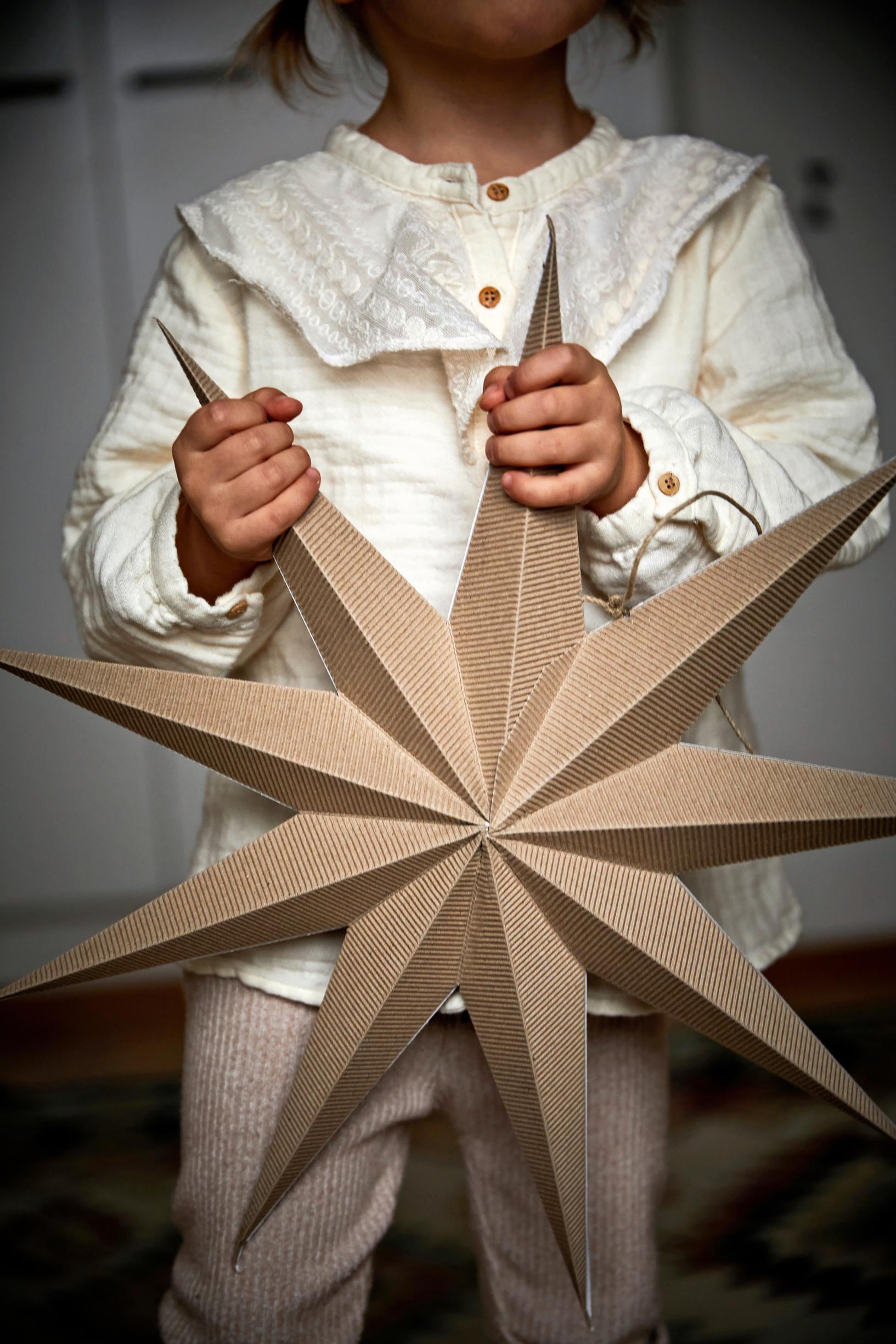 Lapsi pitelee käsissään paperitähteä