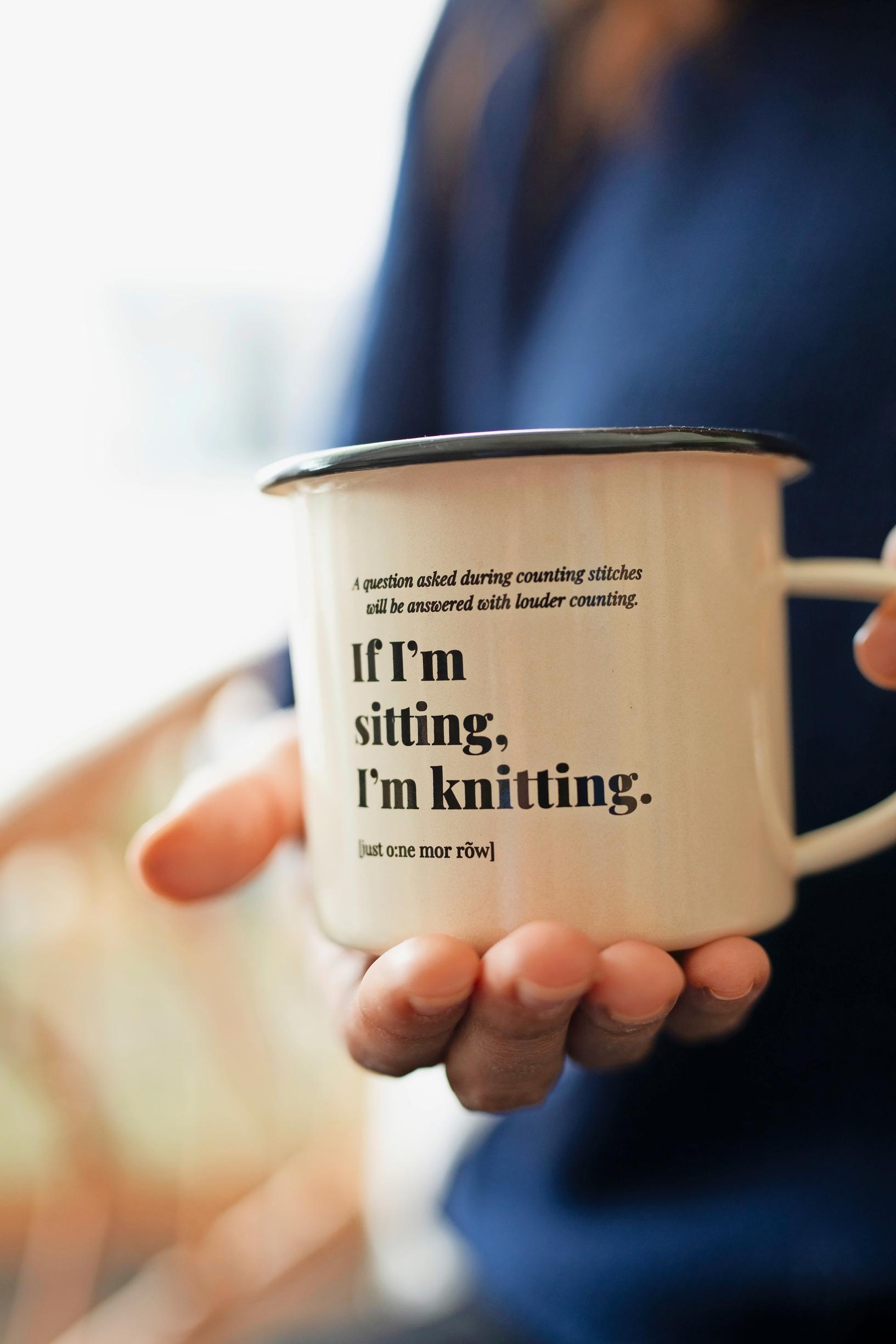muki, jossa teksti: if i'm sitting, i'm knitting.