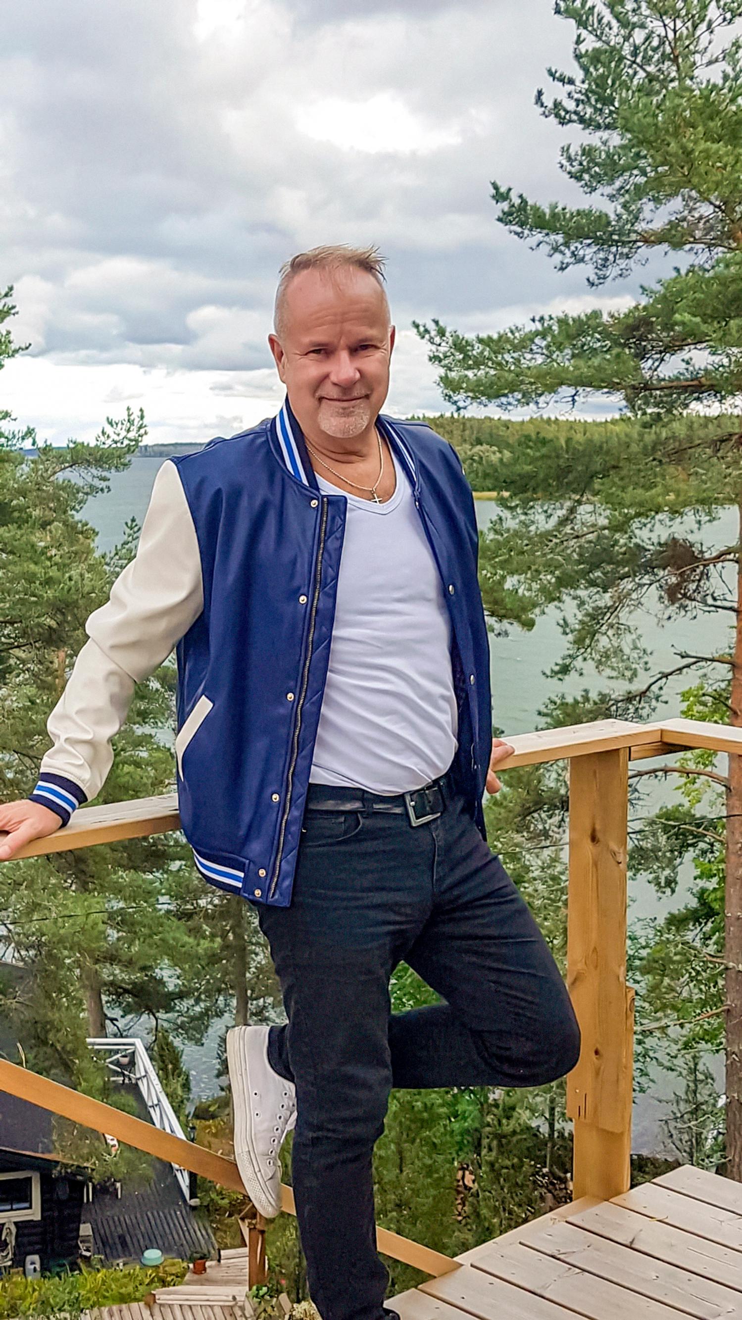 laulaja Petri Laaksonen nojaa terassin kaiteeseen korkealla mäellä, taustalla merta