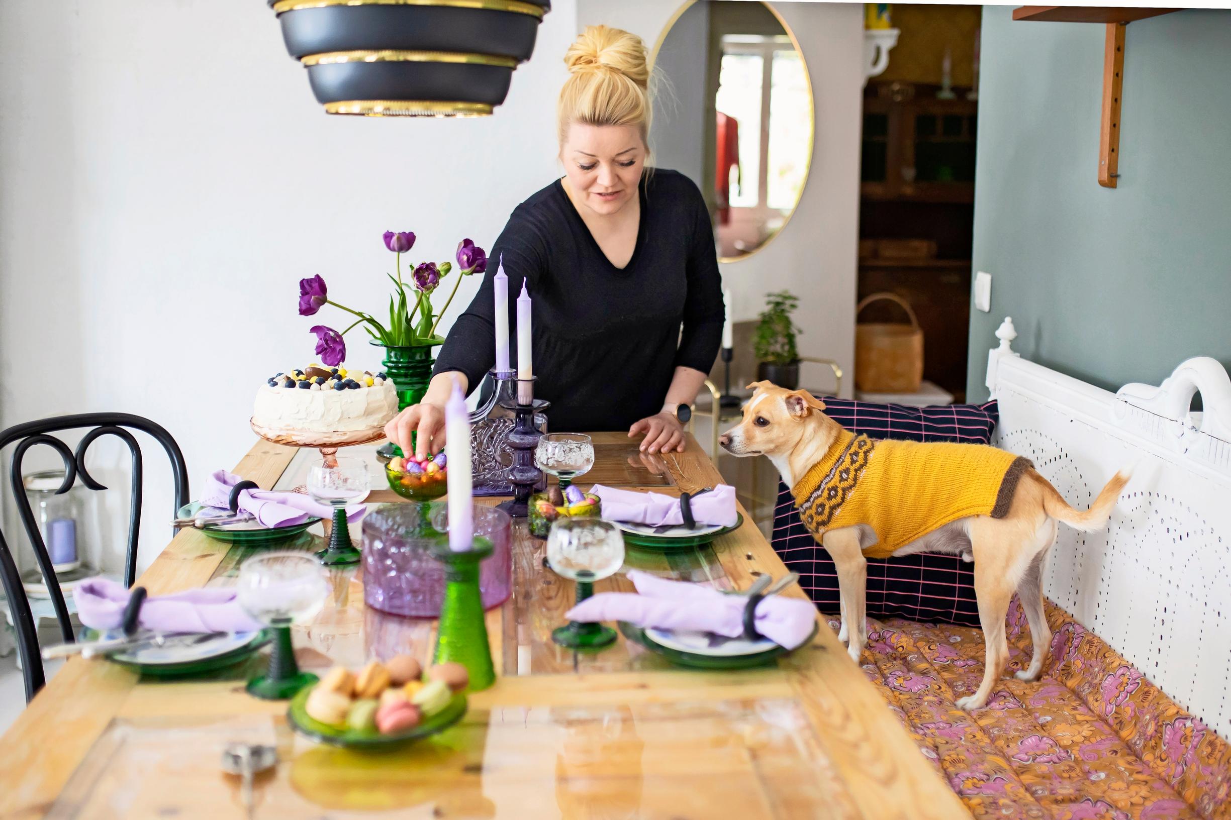 Anu riukulehto ruokailutilassa. Violetti kattaus.
