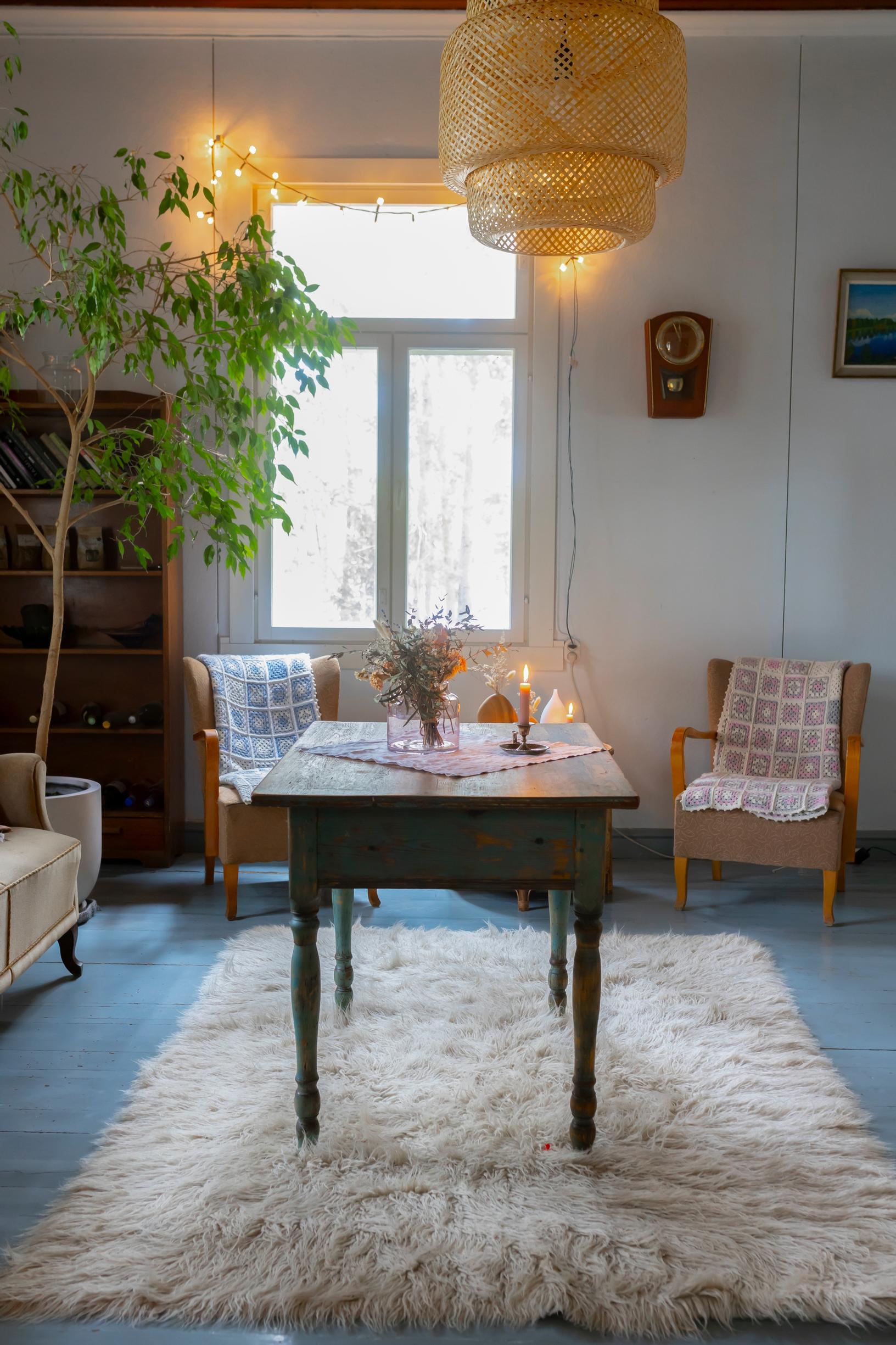 Puulattia, vanhoja huonekaluja ja valkoinen pörrömatto.