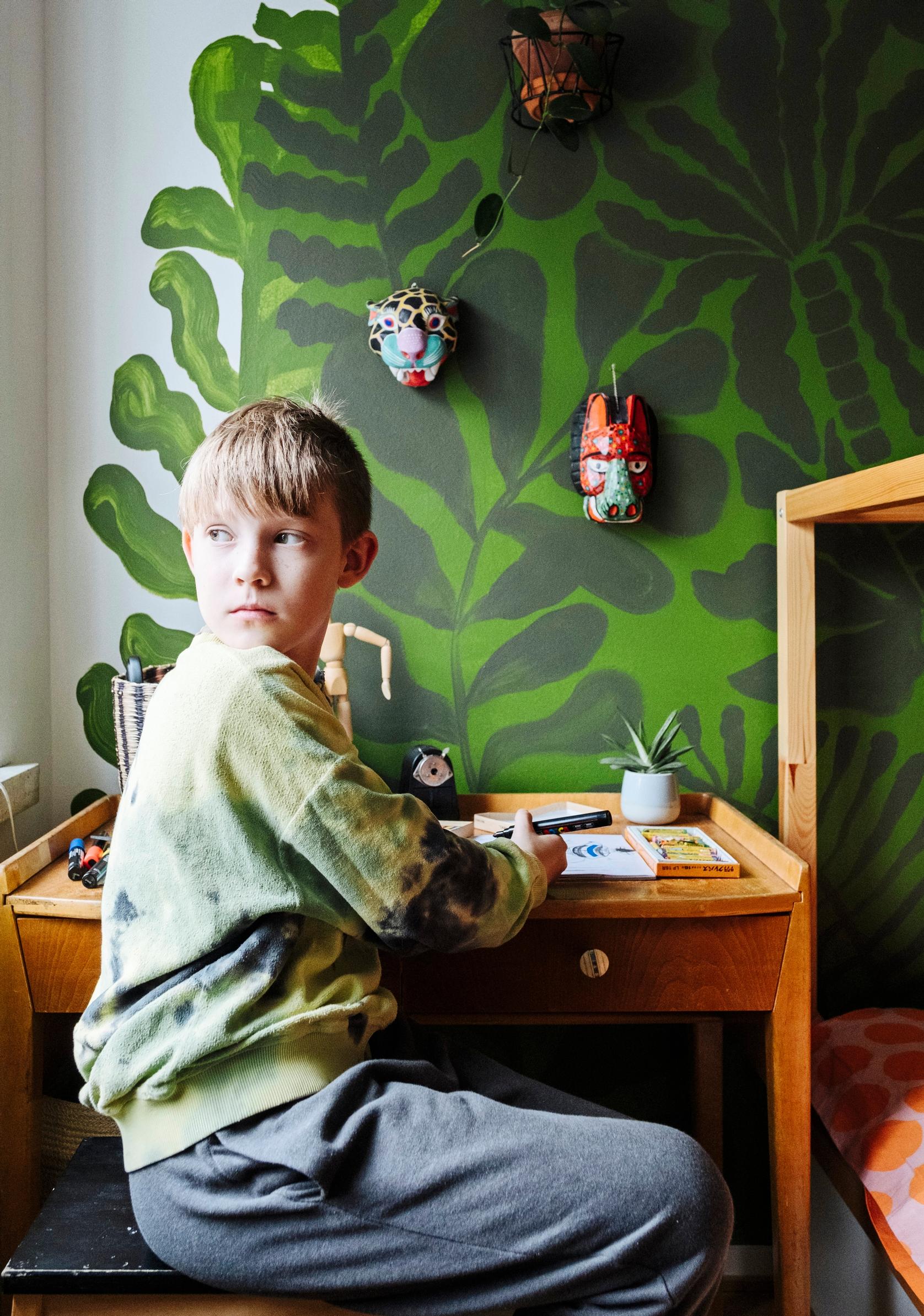 Perheen lapsi kirjoituspöydän ääressä