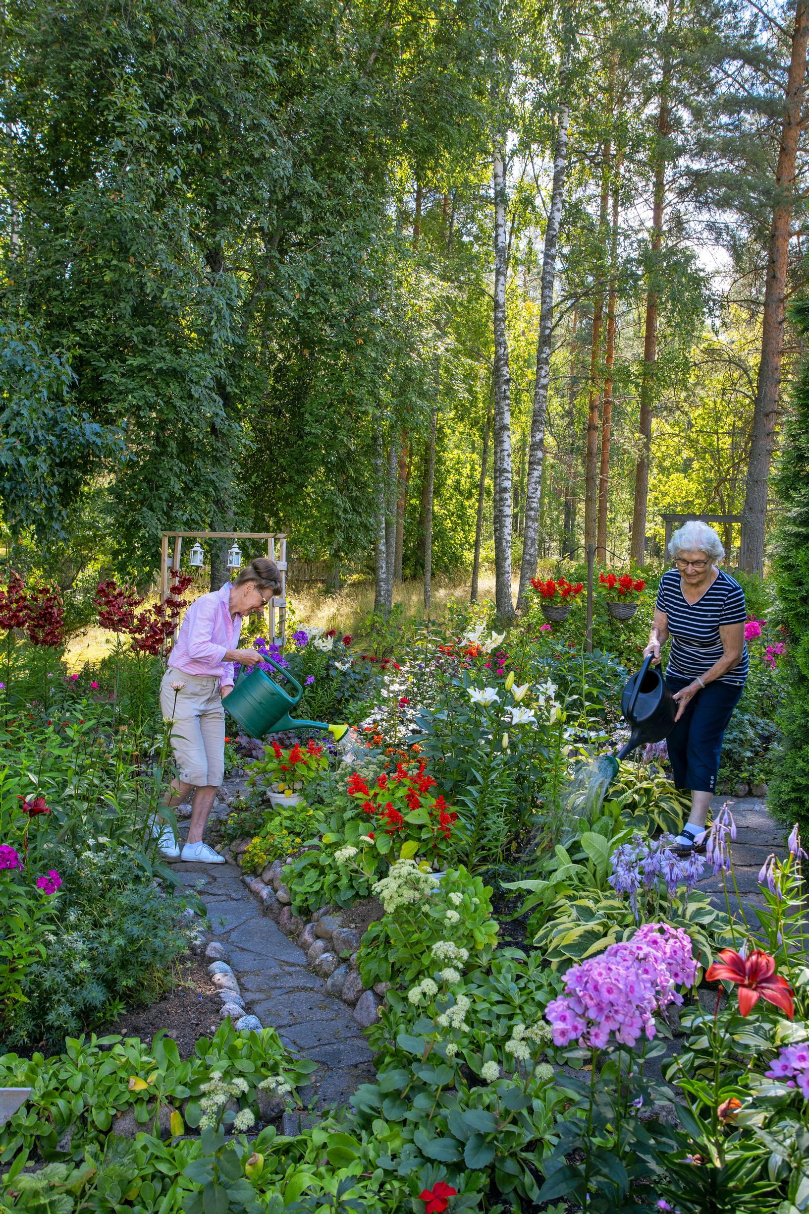 Anja ja Sirpa puutarhatöissä kerrostalonsa pihalla