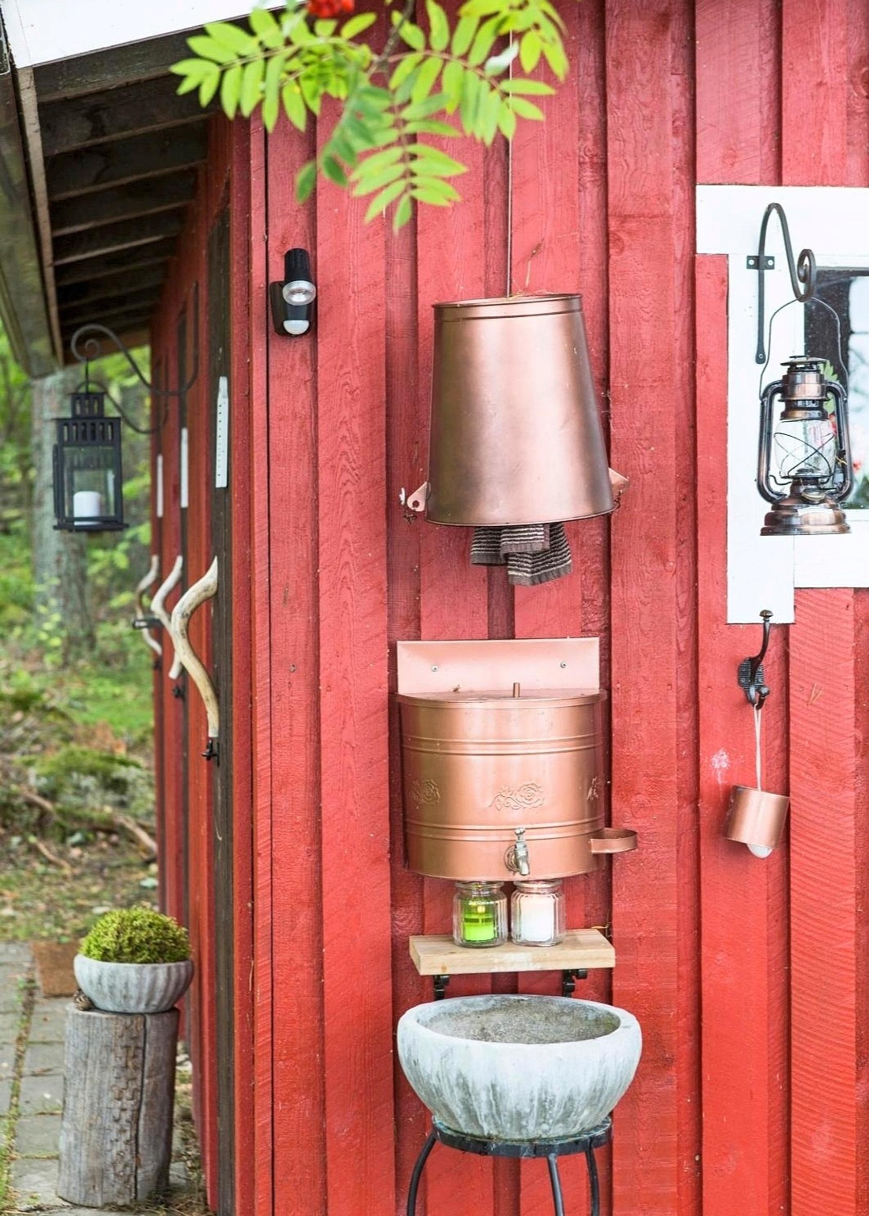 Käsienpesupaikka huussin ulkoseinässä