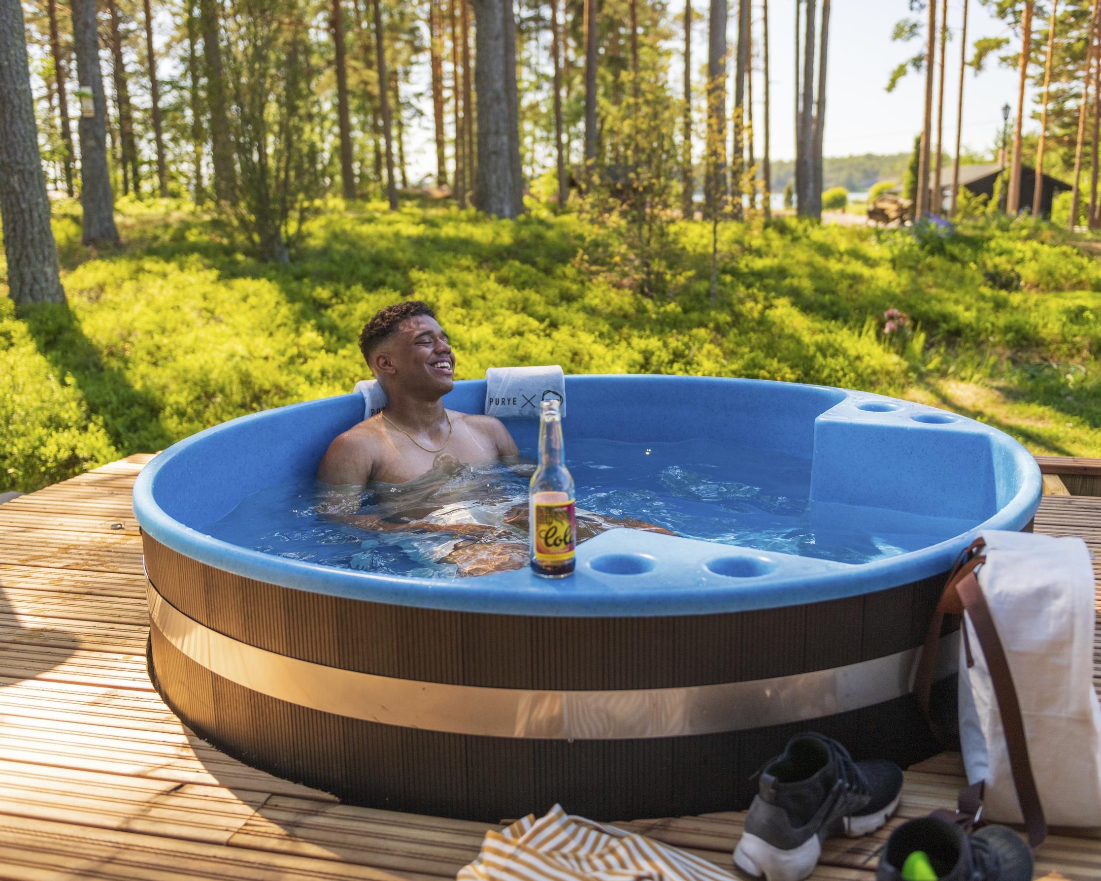 mies paljussa terassilla, taustalla kanervikko ja puita