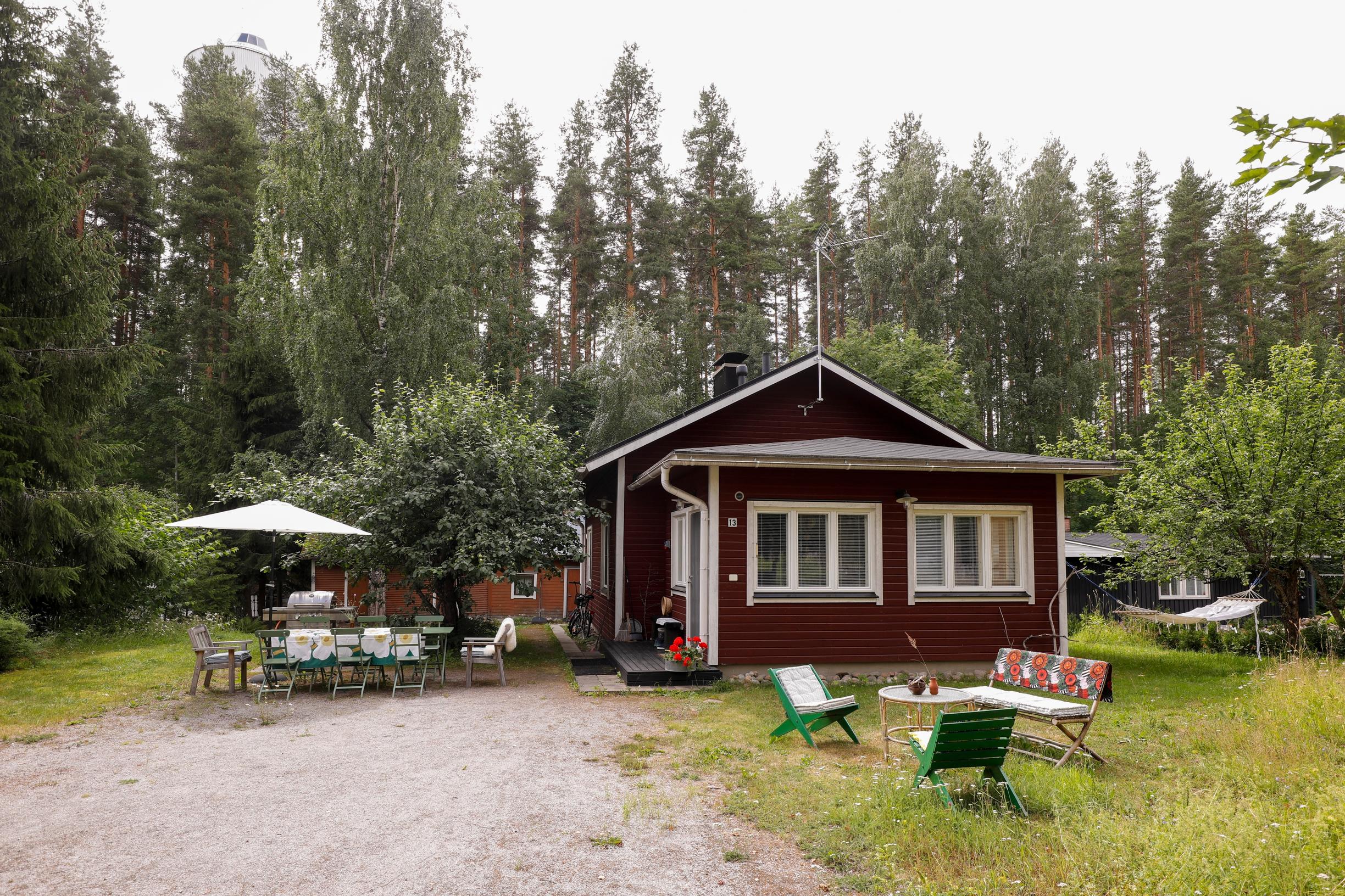 Punainen mökki ja sen pihamaa.