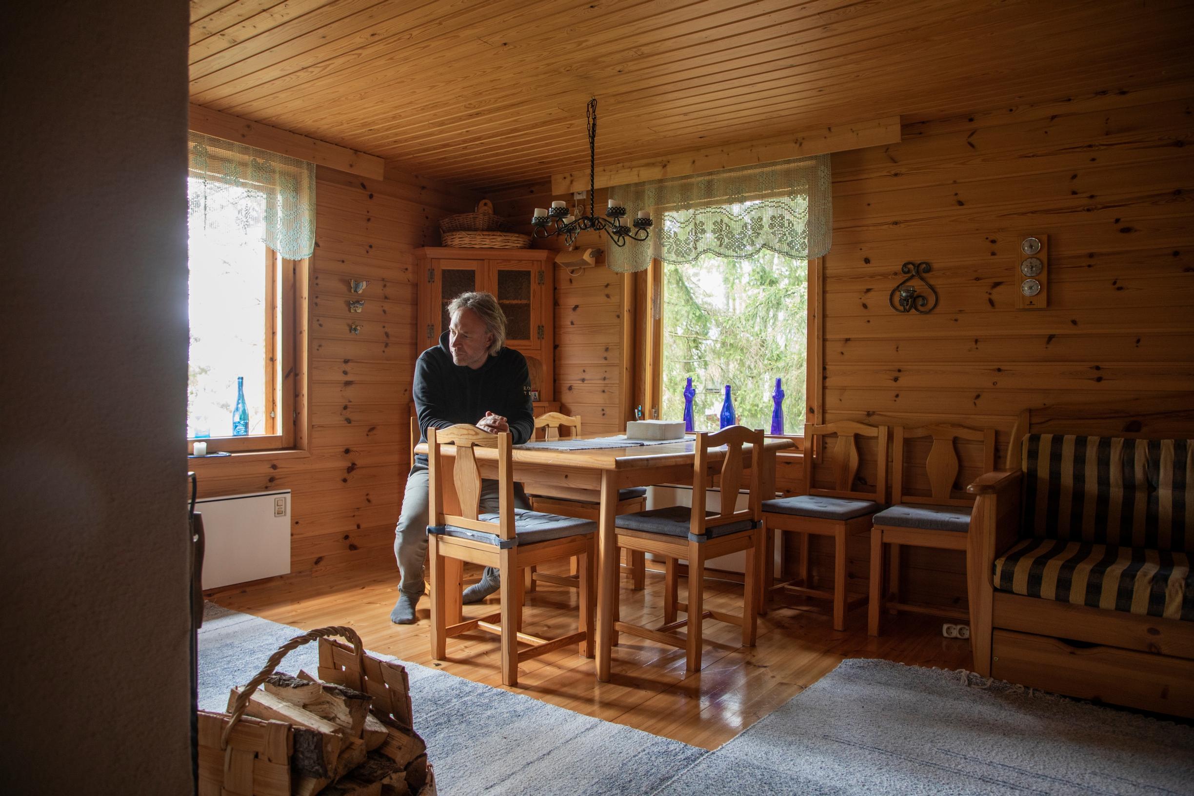 Kari Aihinen istuu mökkinsä tuvassa