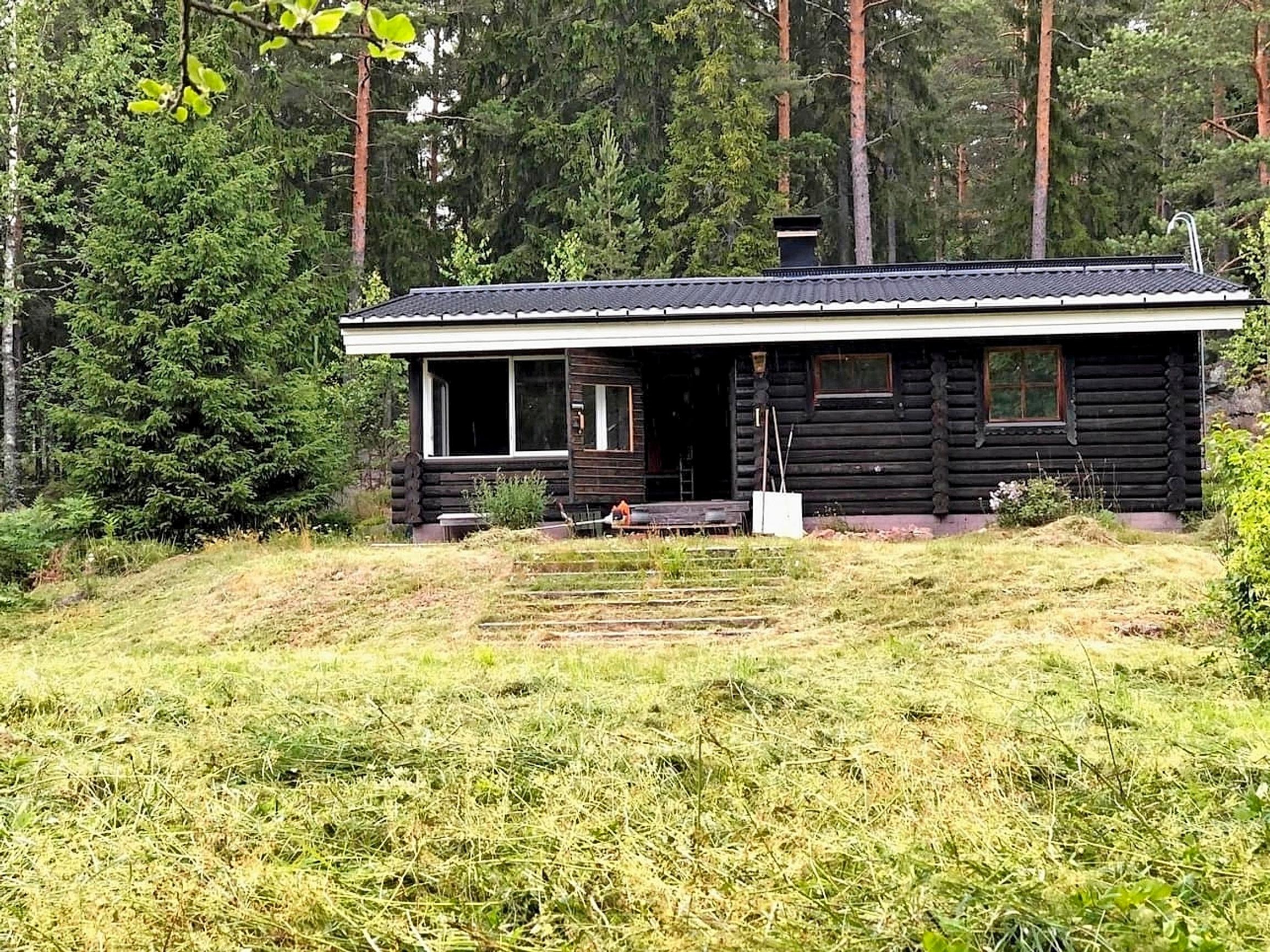 vanha tumma hirsimökki kumpareella