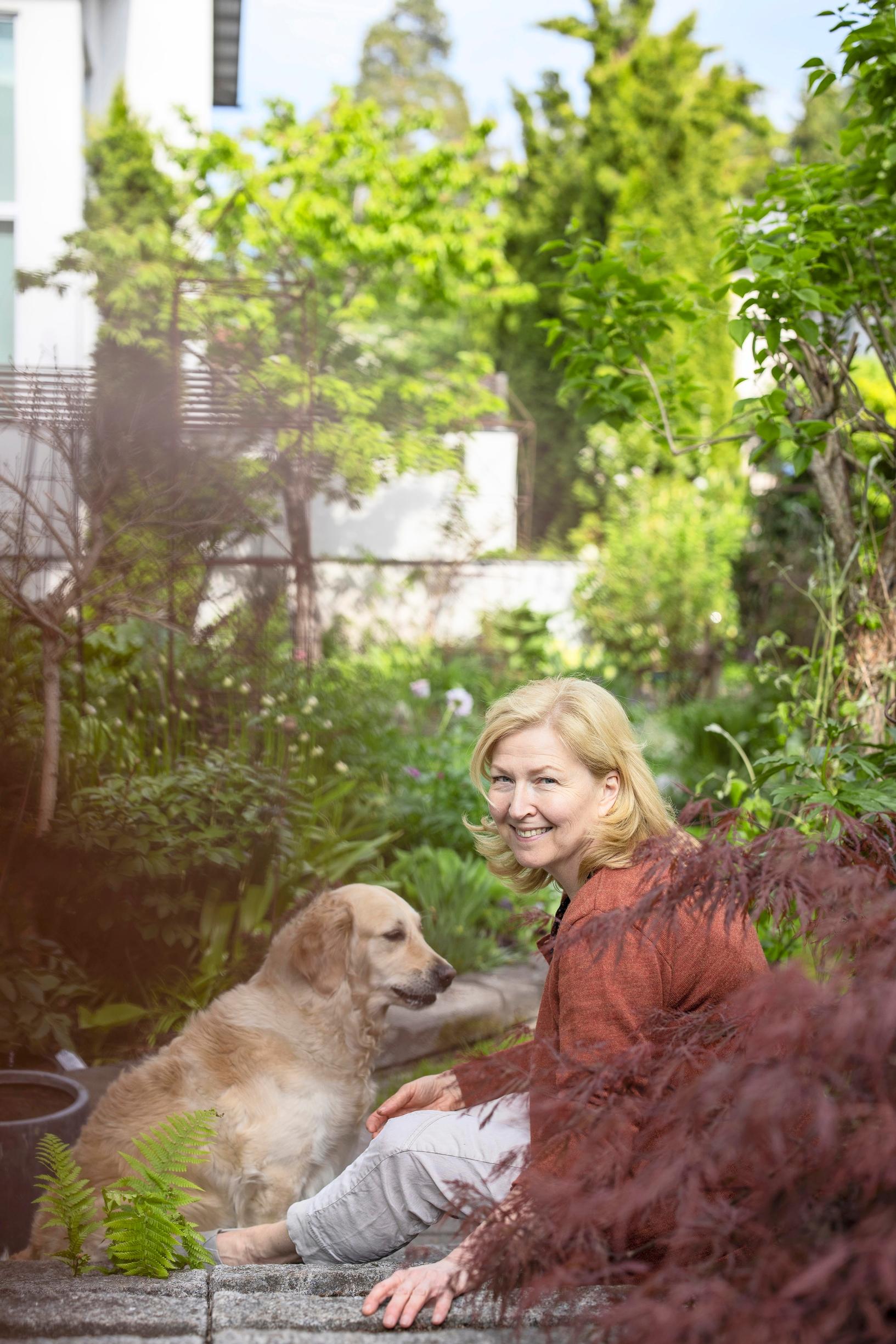 Laura nauttii kasvien hoidosta ja katseluta. Vierellä Ebba-koira.