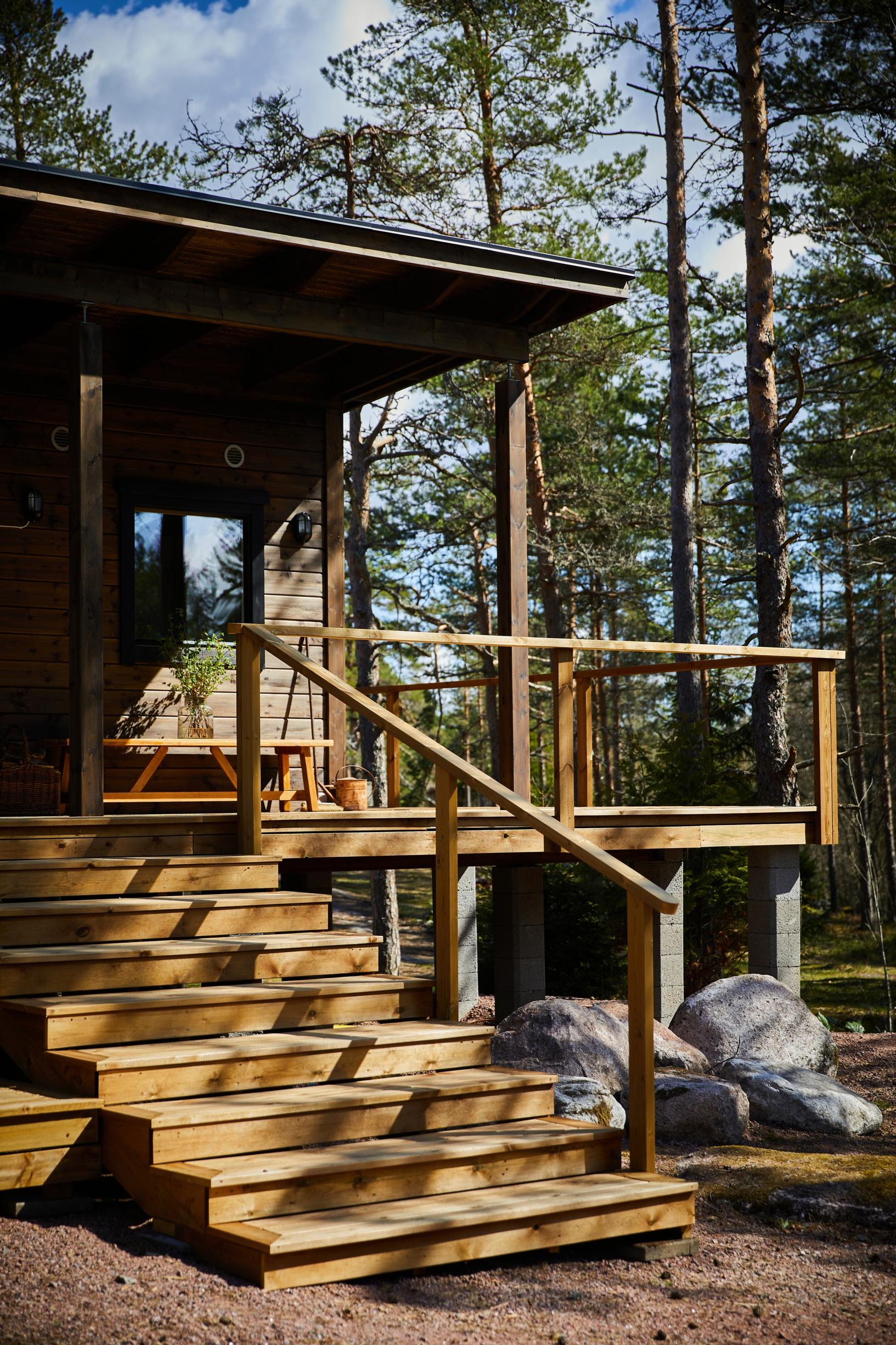 portaat ja terassia mökillä, jonka taustalla mäntymetsää