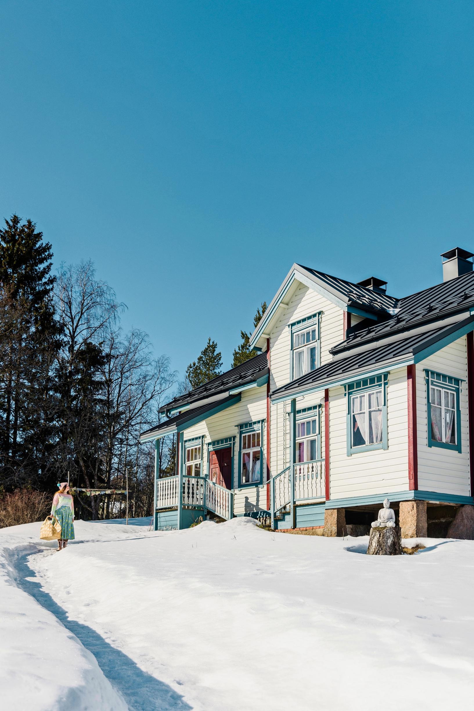 Valkoinen hirsitalo ulkoapäin