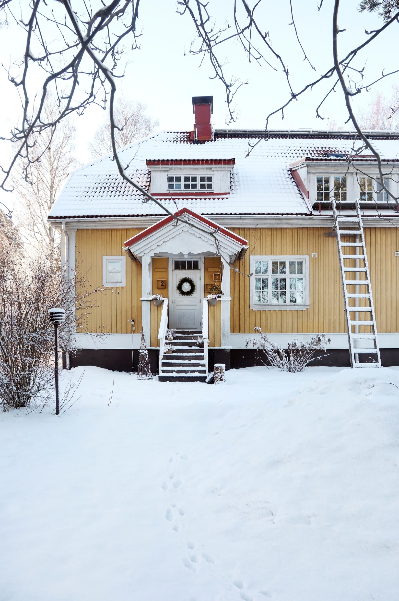 Keltainen puutalo lumimaisemassa