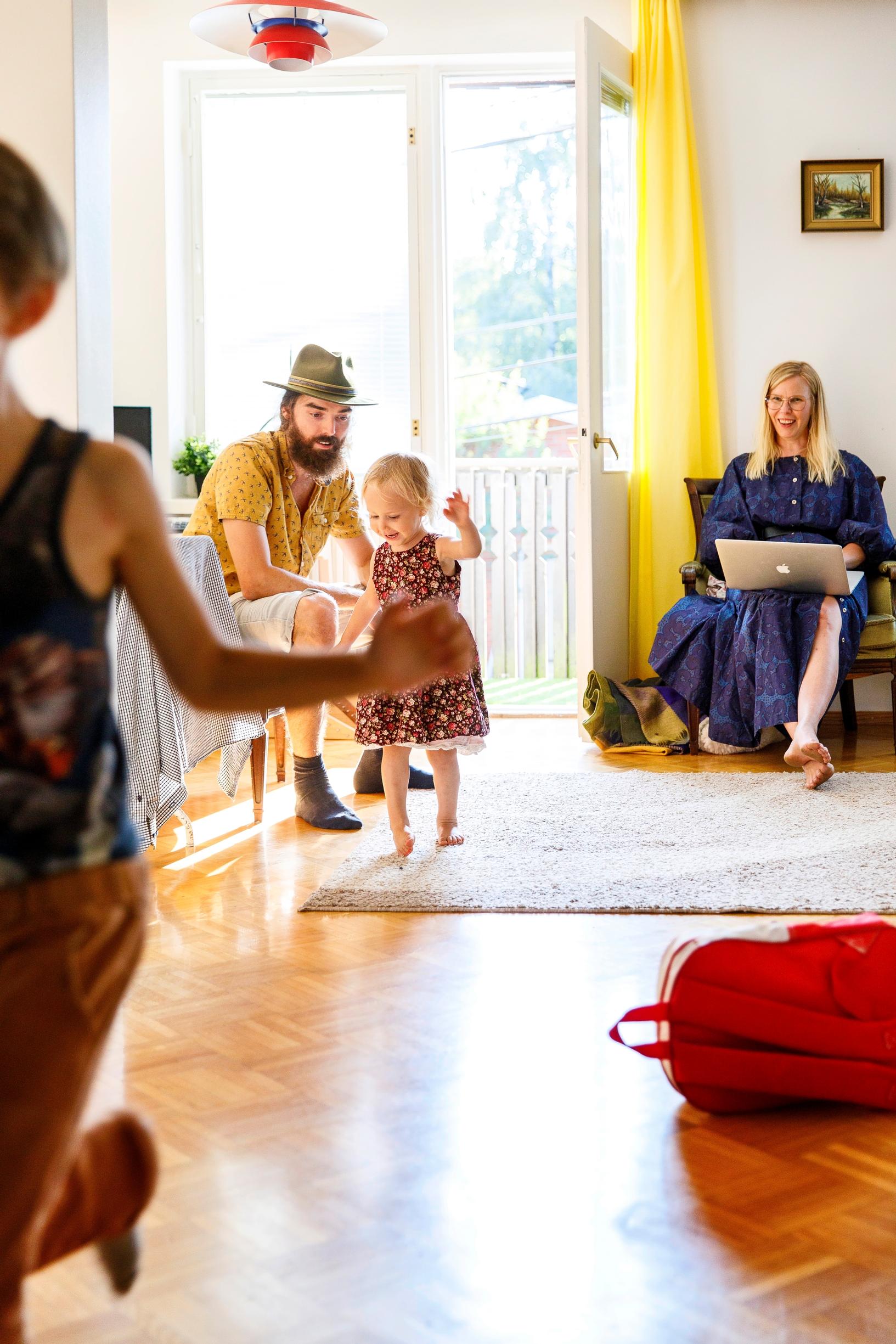 Aikuiset katsovat lasten touhua olohuoneessa
