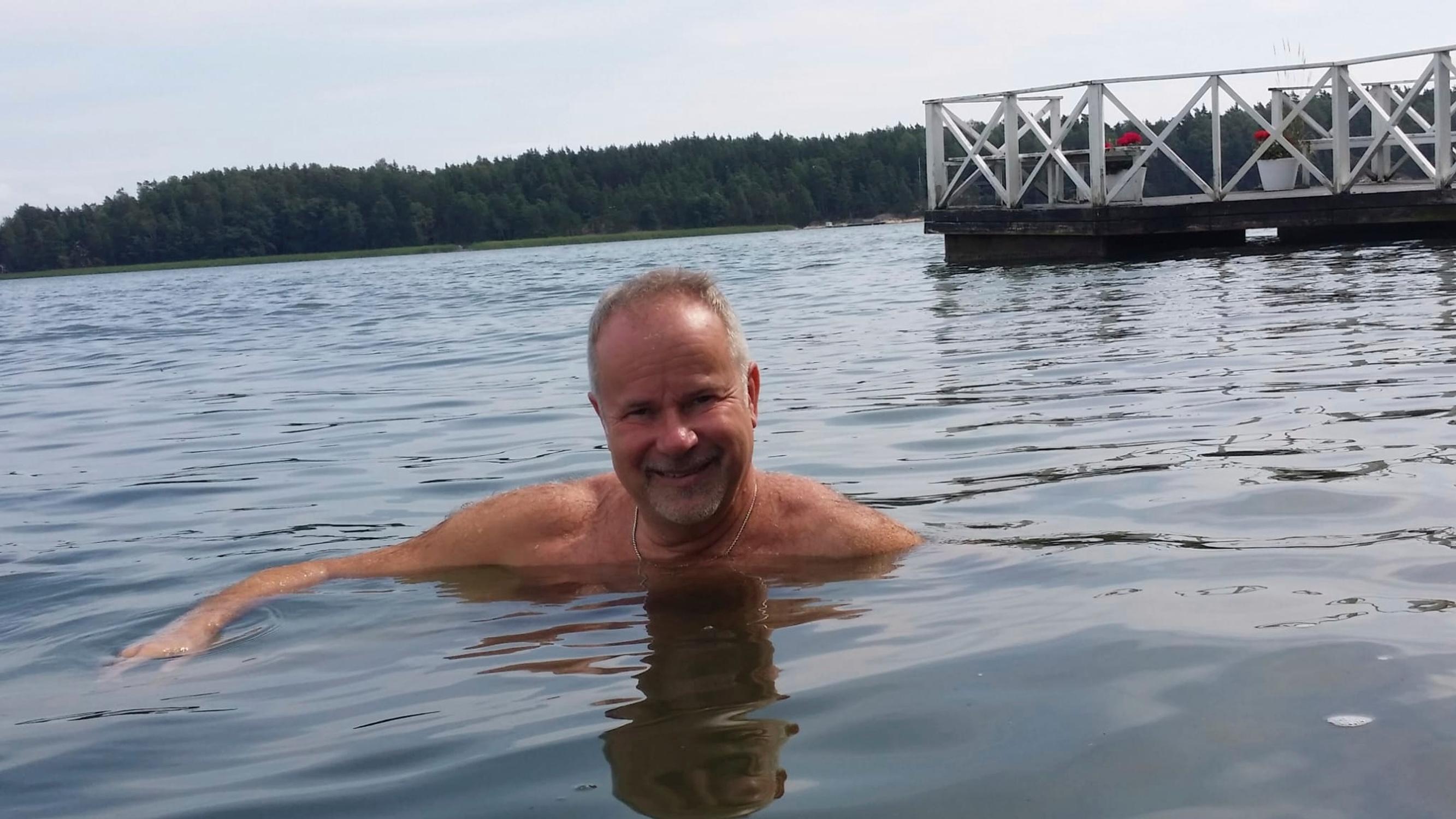 laulaja Petri Laaksonen uimassa, taustalla laituri ja vastarantaa