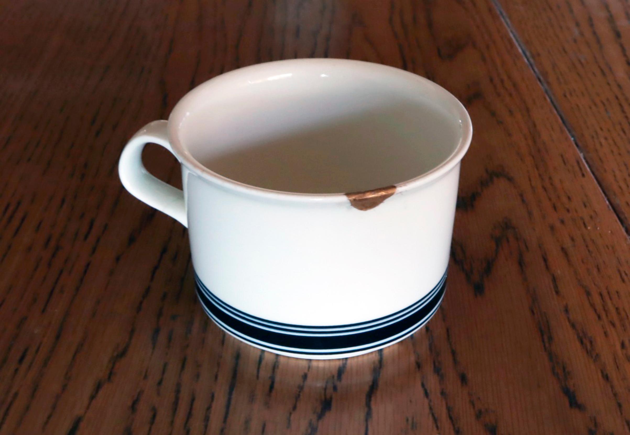 kintsugi-tekniikalla korjattu kahvikuppi pöydällä