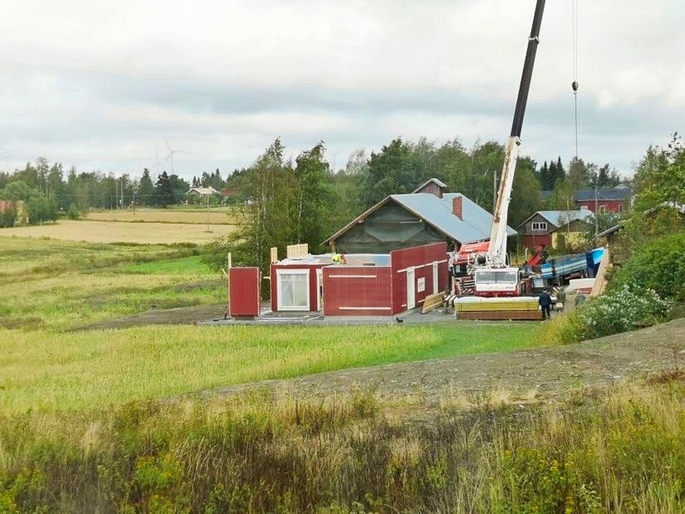 Uutta taloa rakennetaan vanhan ladon tilalle. Valmiit elementit nostetaan nosturilla.