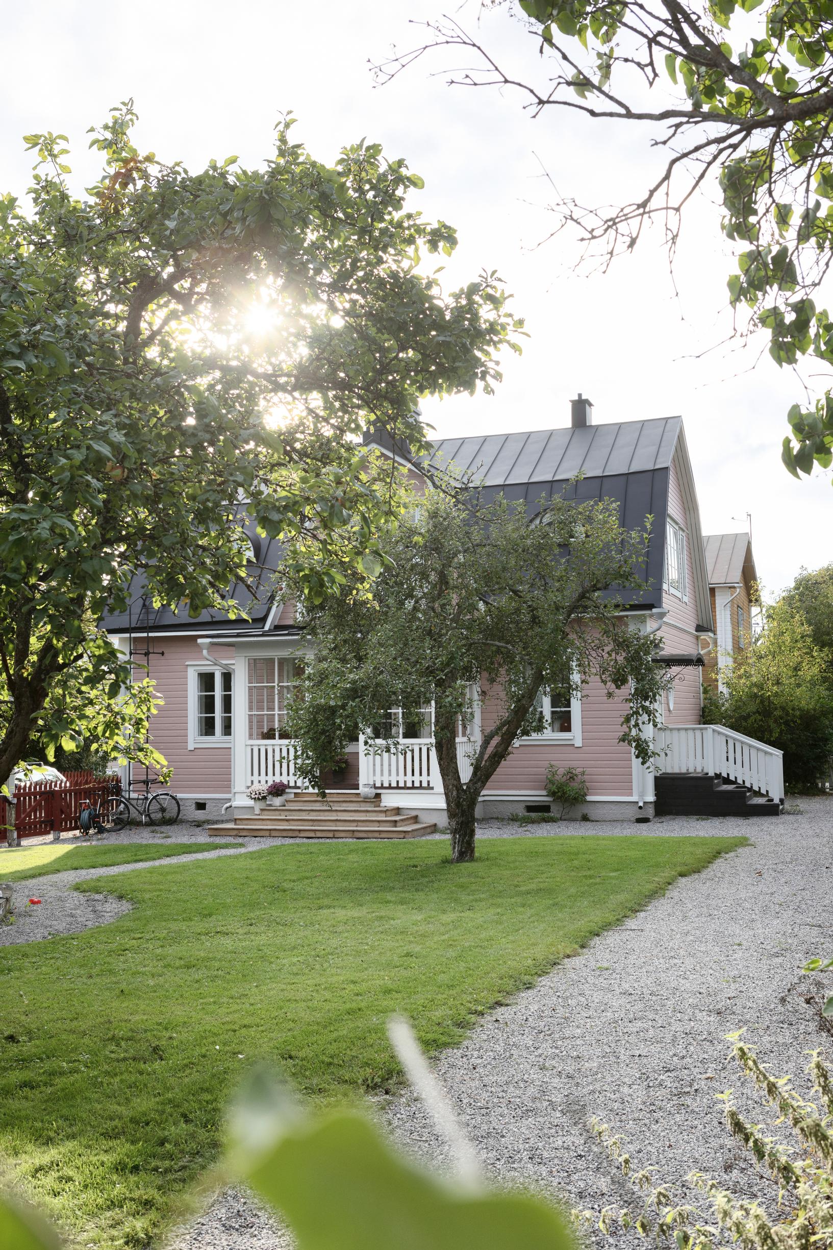 vaaleanpunainen puutalo ja puutarha
