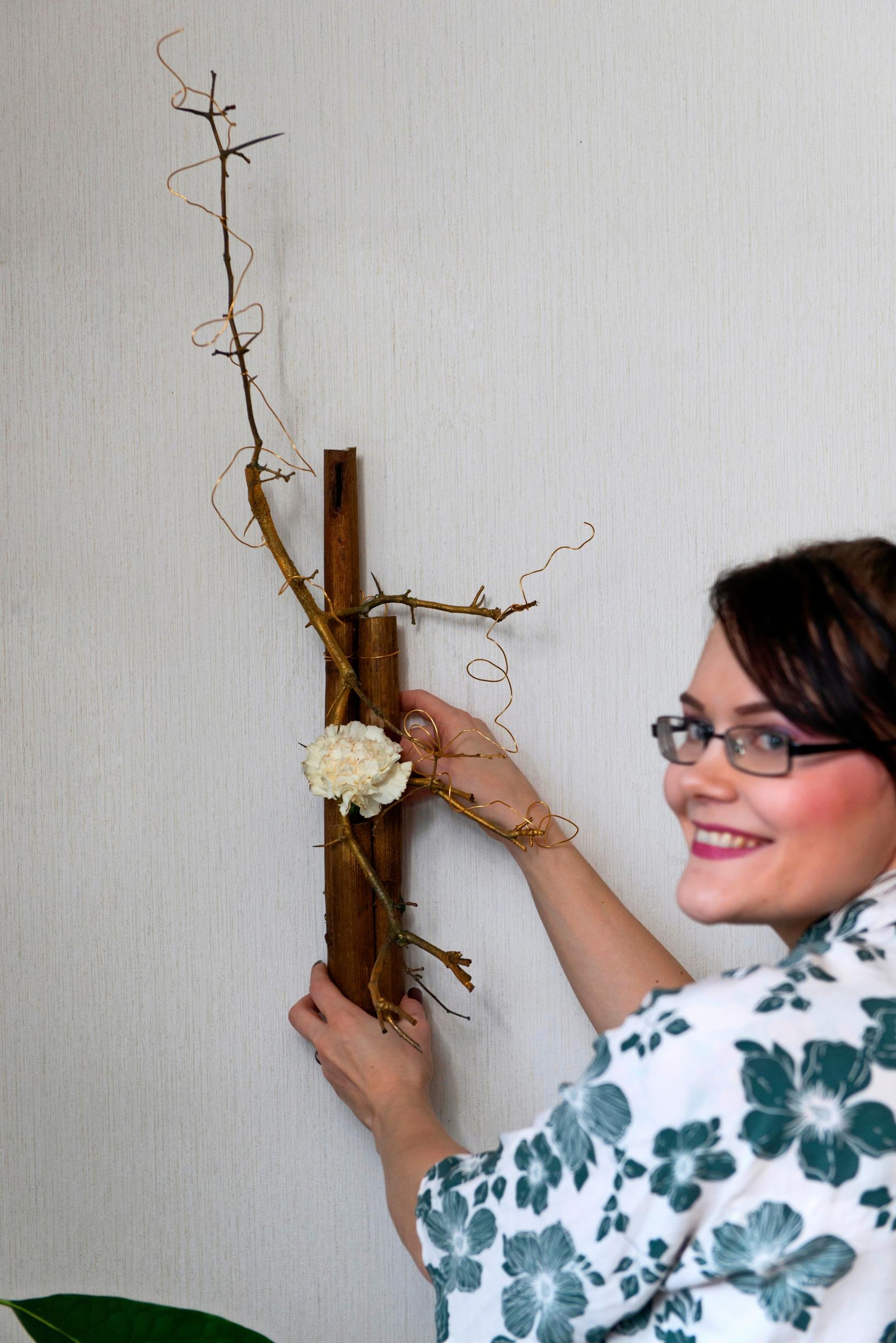 Halla Kantola ja ikebana-asetelma seinällä eli kakebana