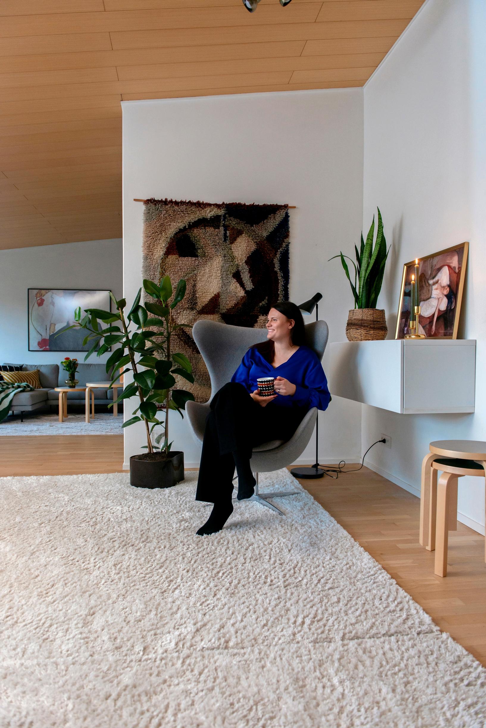 Kuva omakotitalon avarasta olohuoneesta, jossa iso vaalea matto ja design-huonekaluja. 