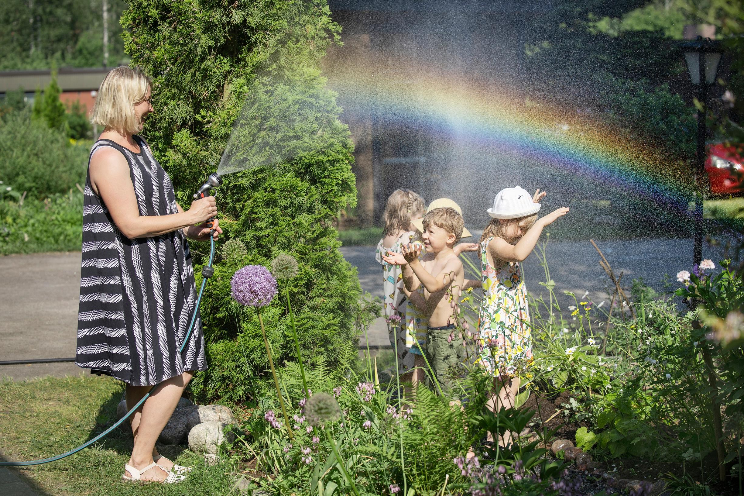 Leikkiä vesiletkulla perhepäivähoitajan puutarhassa