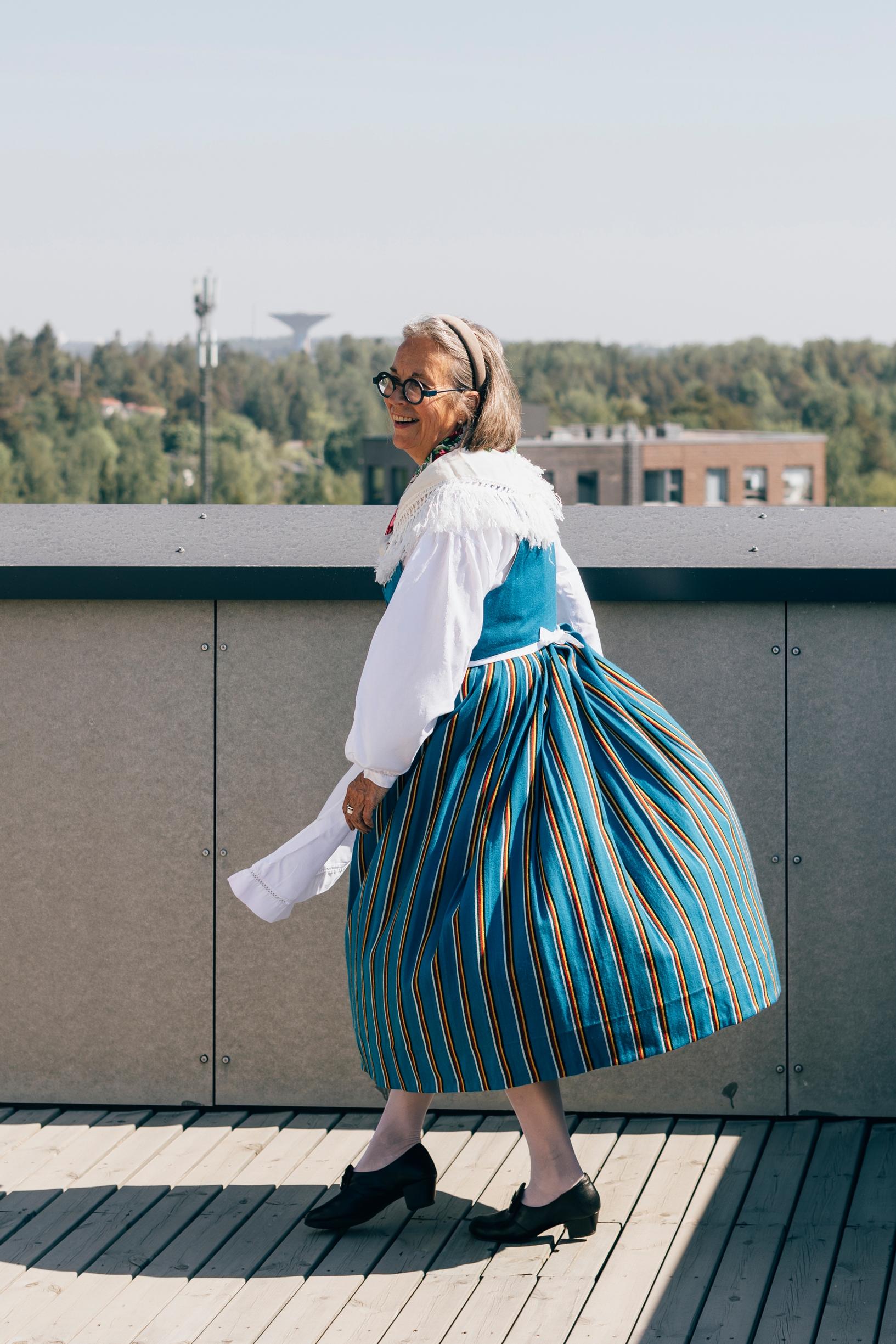 nainen pyörähtää kansallispuvussaan