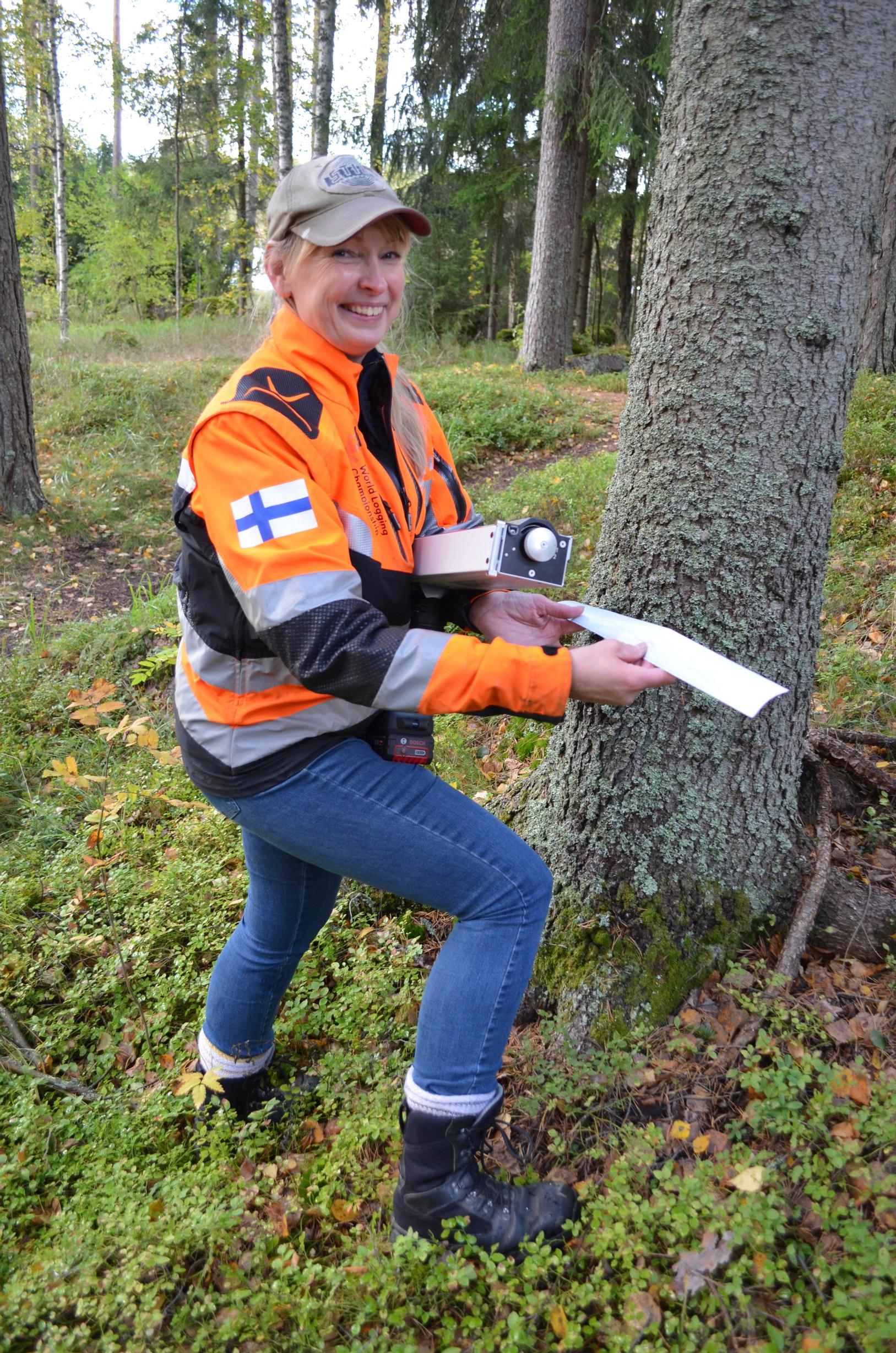 arboristi Mare Luukkonen näyttää tulostamaansa raporttia puun kunnosta metsässä