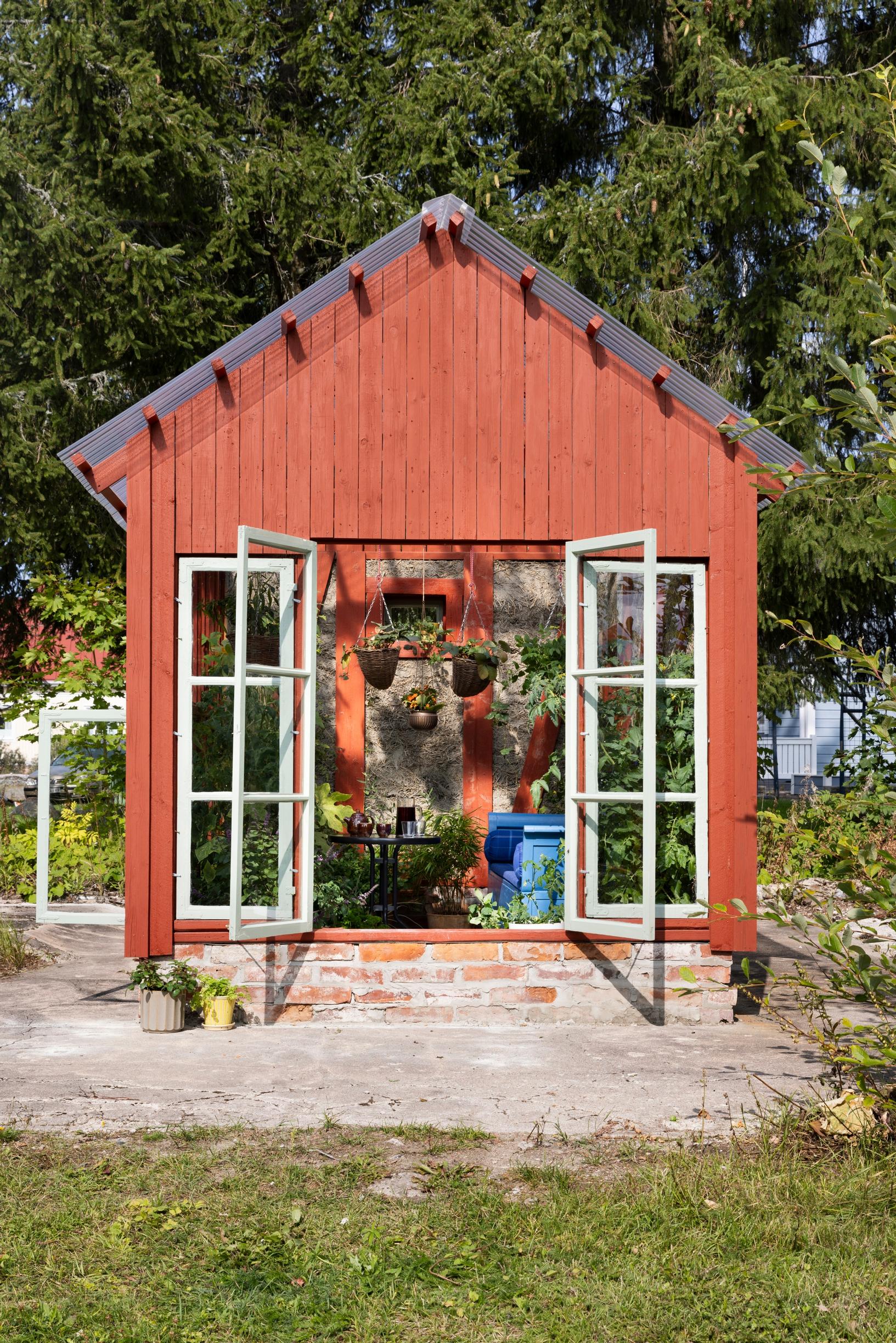 punainen kasvihuone edestä, valkoruudulliset lasiovet avoinna 