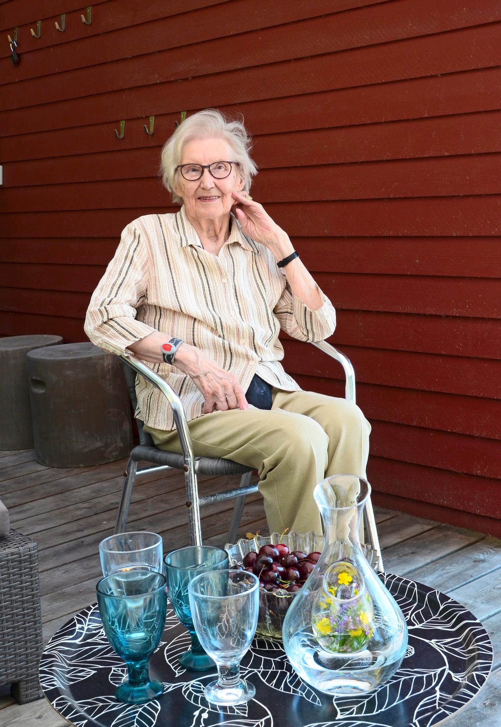 vanha rouva istuu ulkona ja pöydällä tarjoilua