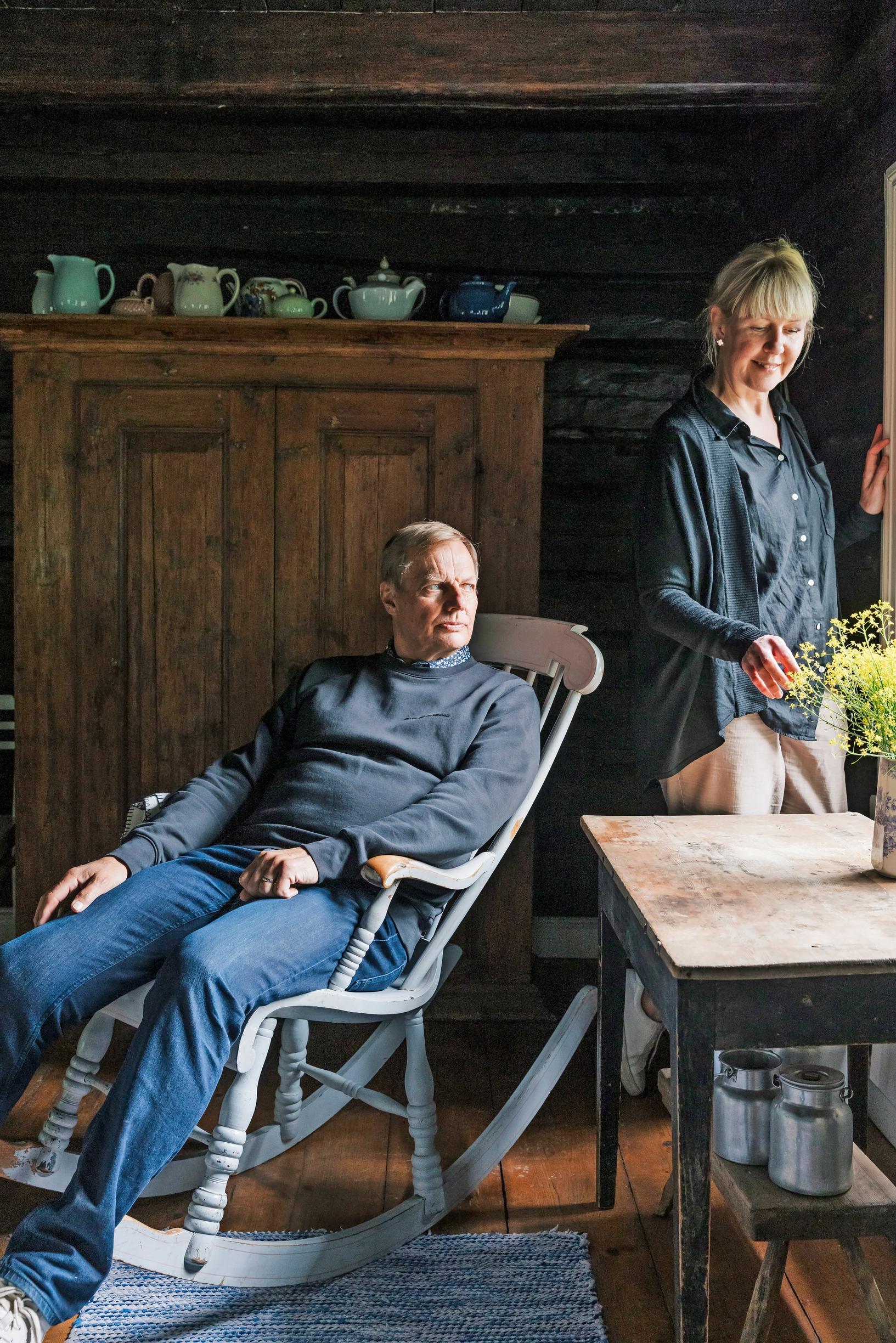 Anne Pakomäki pöydän ääressä, Heikki Hyttinen keinutuolissa