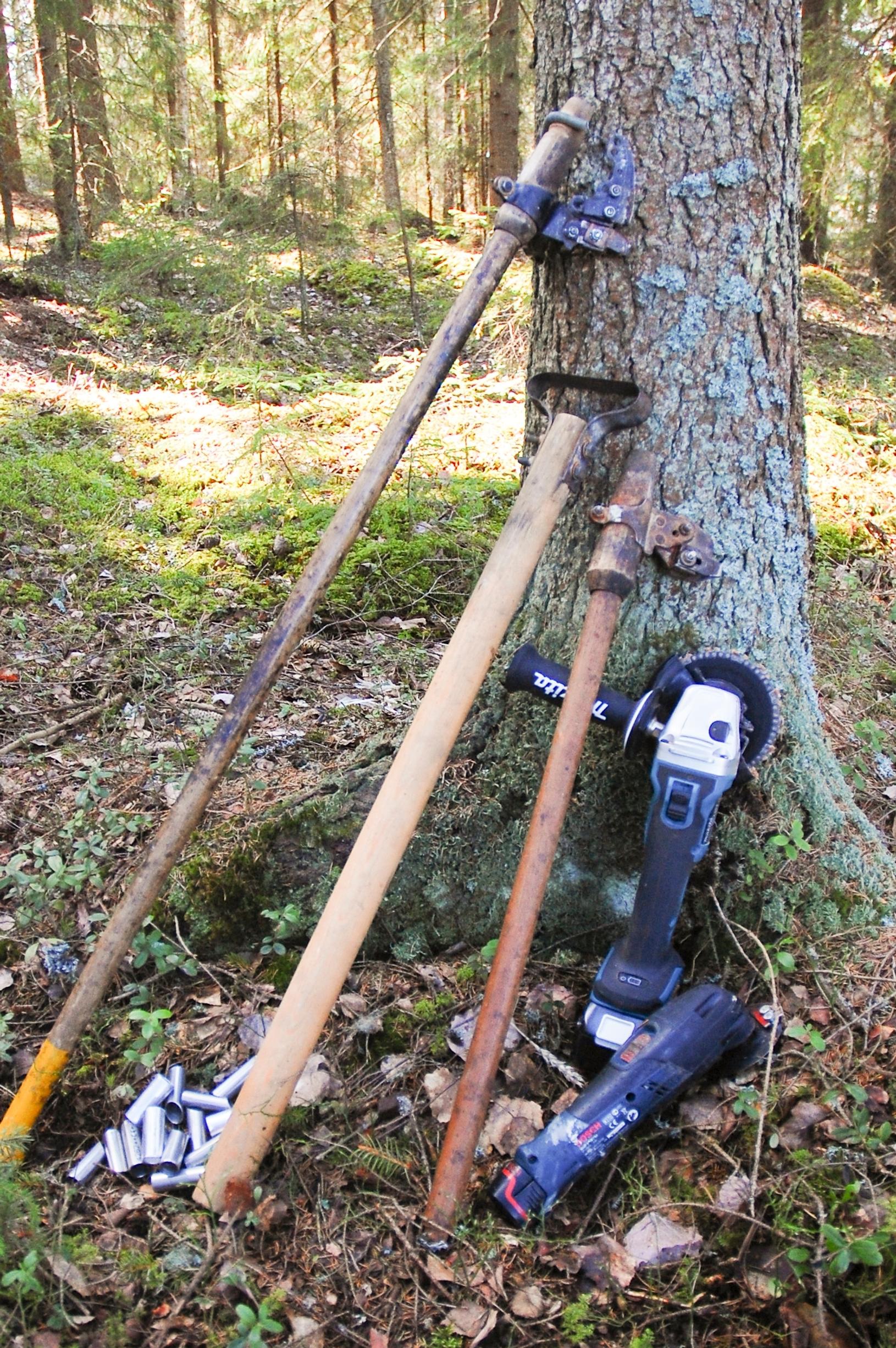 Puun käsittelyyn liittyviä työkaluja puuta vasten aseteltuna.