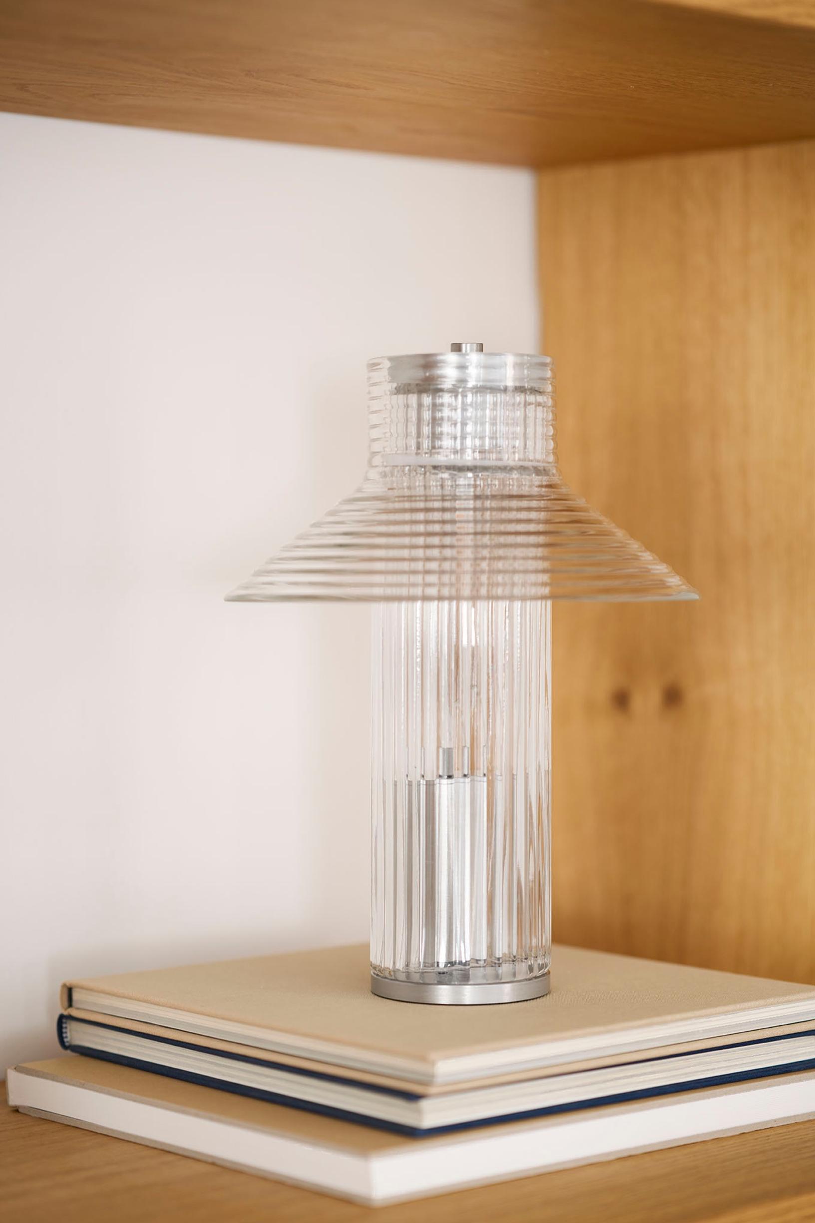 Kahden kirjan päällä alumiinista ja lasista tehty majakan näköinen U14 Sletterhage -pöytävalaisin