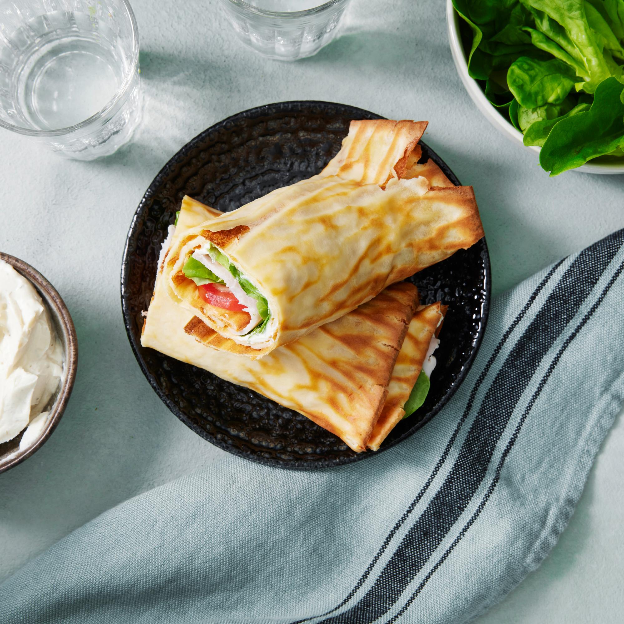 Raejuustorieska eli raejuustosta tehty flarbread rullattuna lautasella
