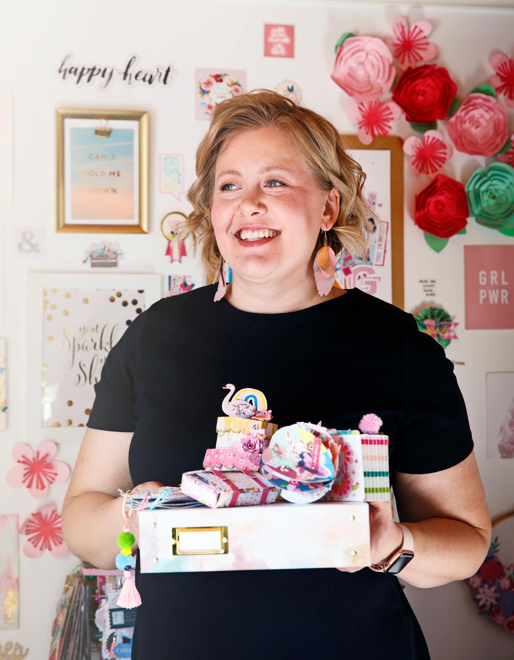 nainen pitää käsissään askartelutarvikkeita