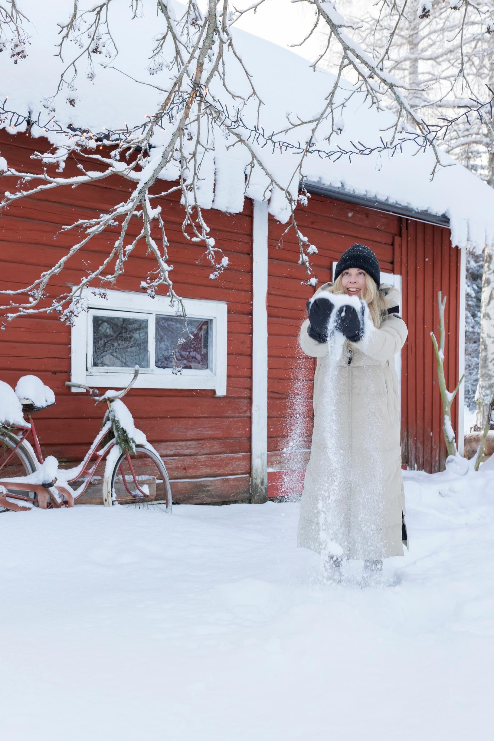 Meeri heittää lunta pihalla