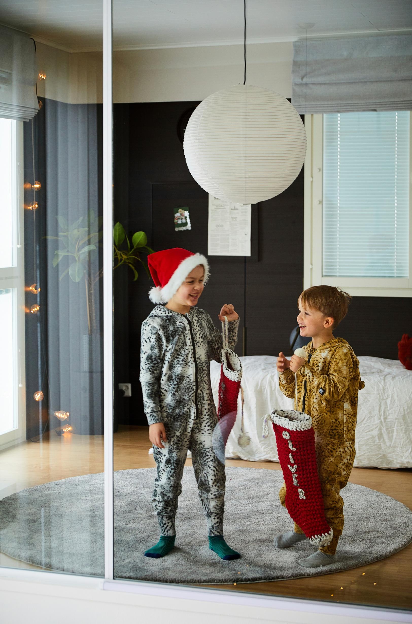pikkupojat jouluasuissa pyöreällä matolla