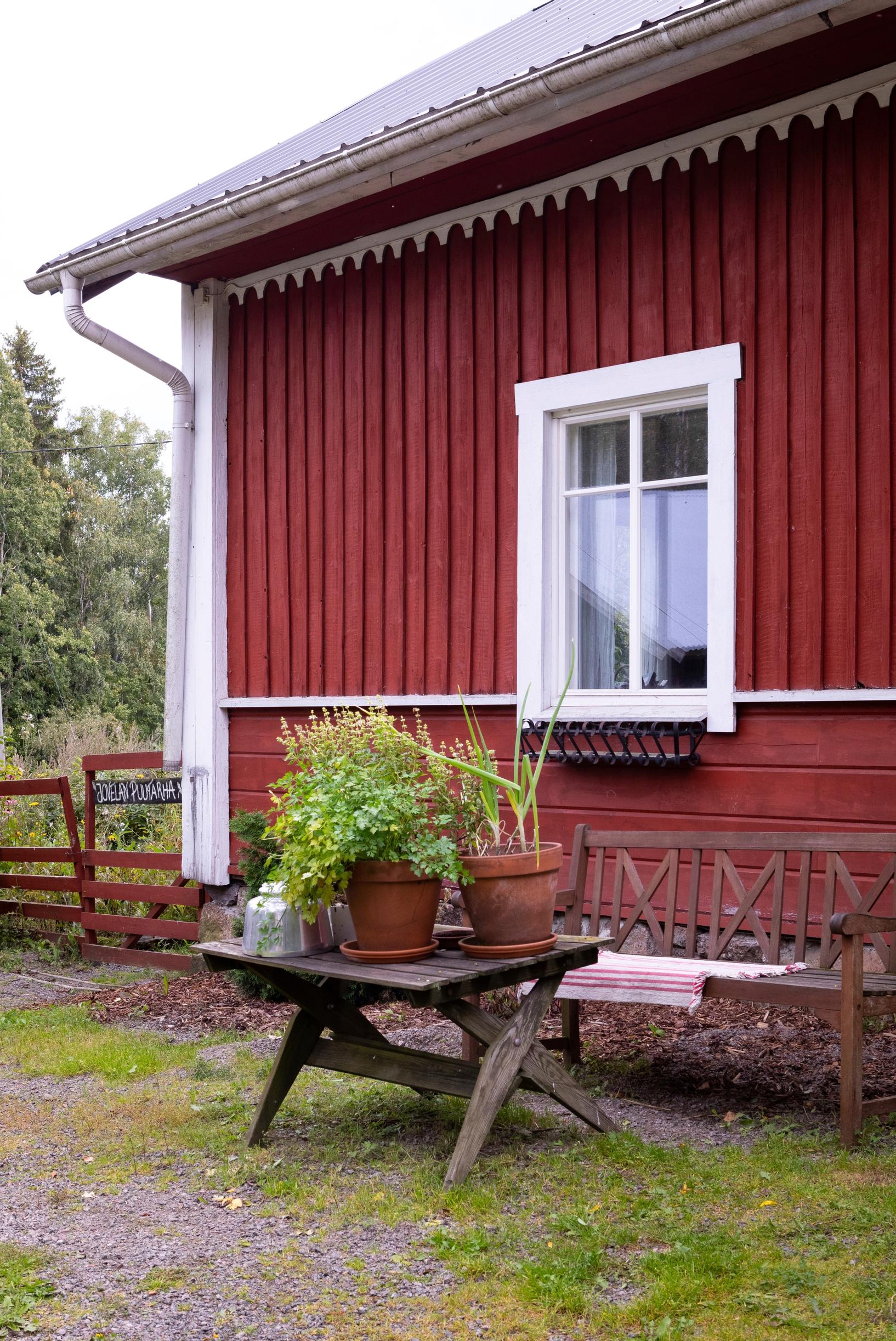 pöytä ulkona punaisen puutalon vierellä