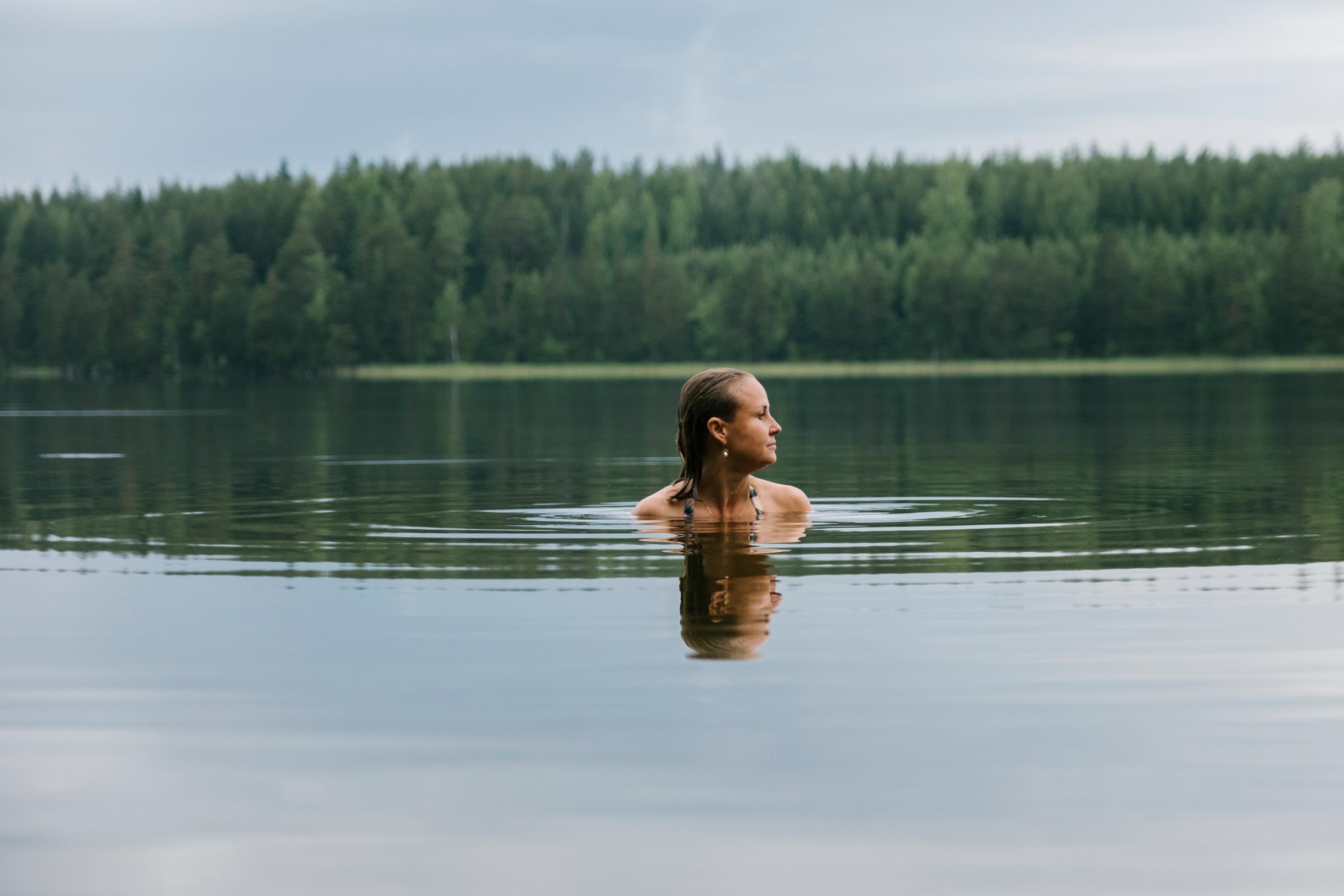 nainen uimassa järvessä