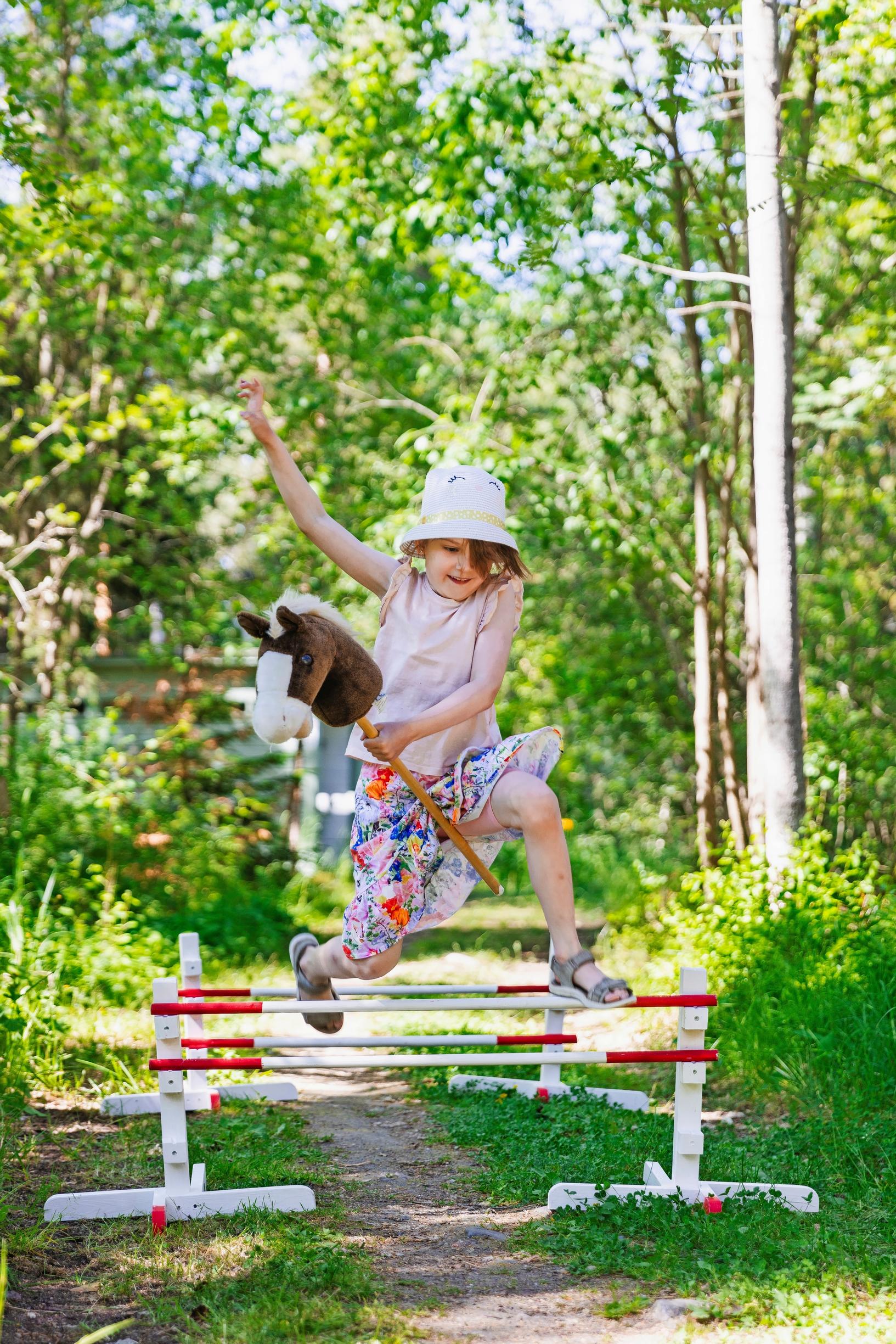 Matilda hyppää esteradalla keppihevosella