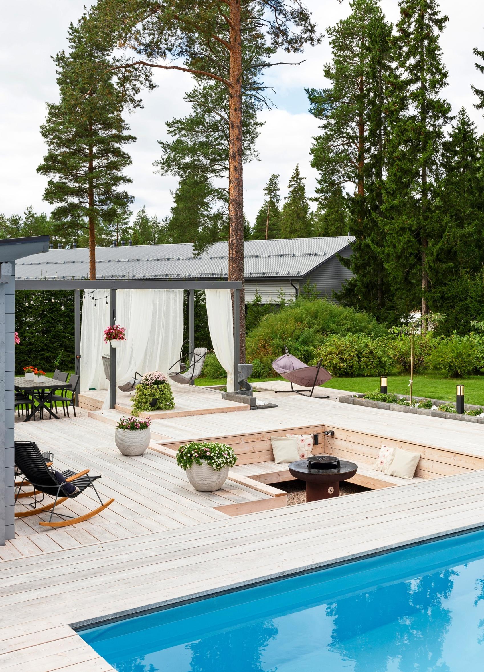 Pergola terassin nuotiopaikan takana