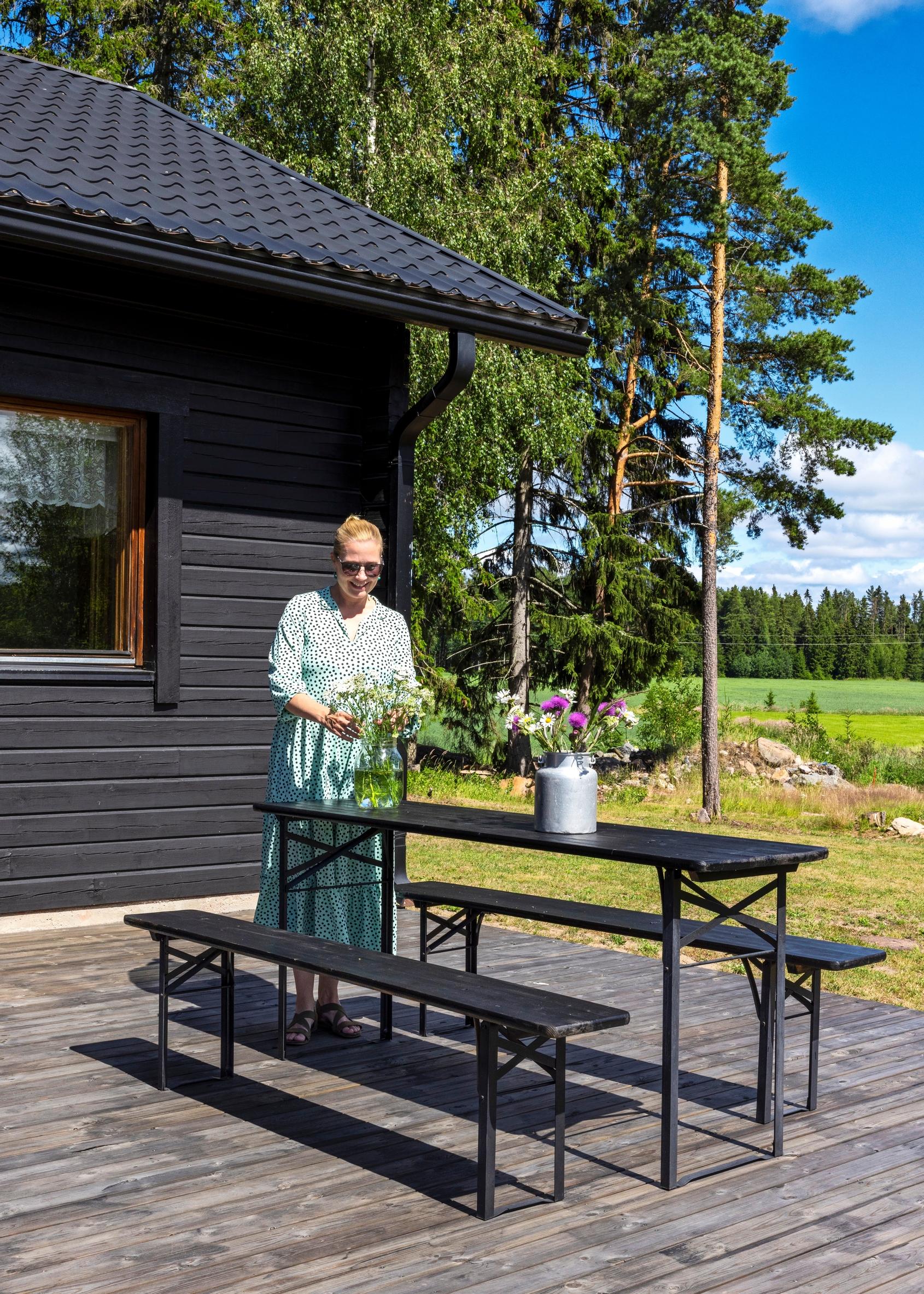 Nina Välimaa ulkona pöytäryhmän luona terassilla.
