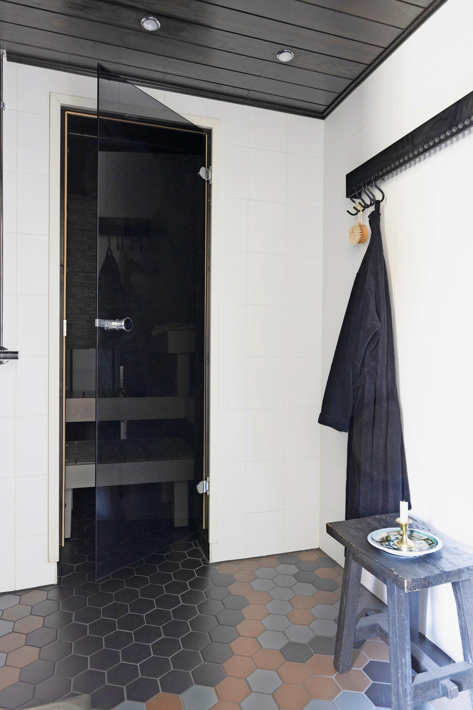 Musta sauna ja valkoinen kylpyhuone