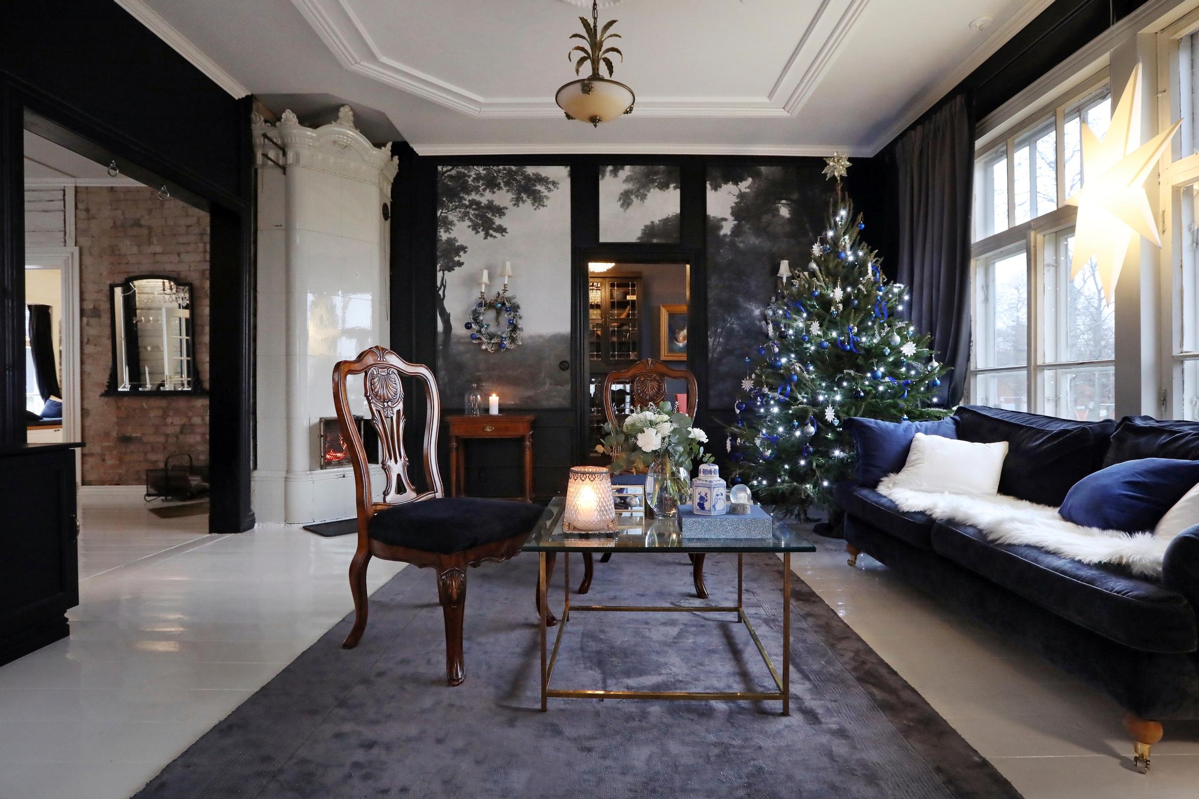 Vanhan ratsutilan mustalla ja valkoisella sisustettu tilava kirjastohuone